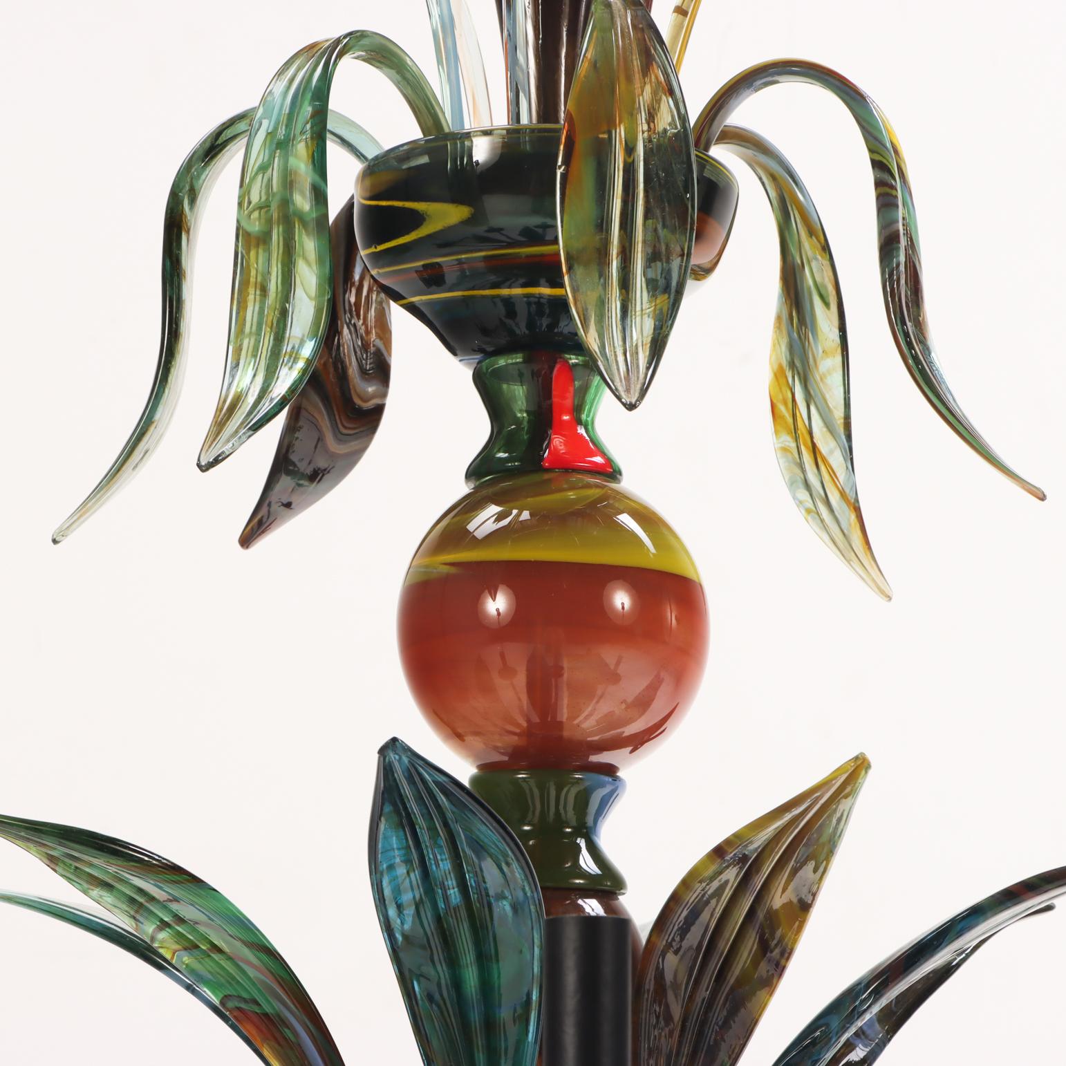 Dieser Kronleuchter aus mundgeblasenem Glas ist ein lebhaftes Beispiel für die Handwerkskunst des späten 20. Jahrhunderts in Murano und verfügt über einen zentralen gedrehten Schaft, der mit sechs nach oben gerichteten tulpenförmigen Glaselementen