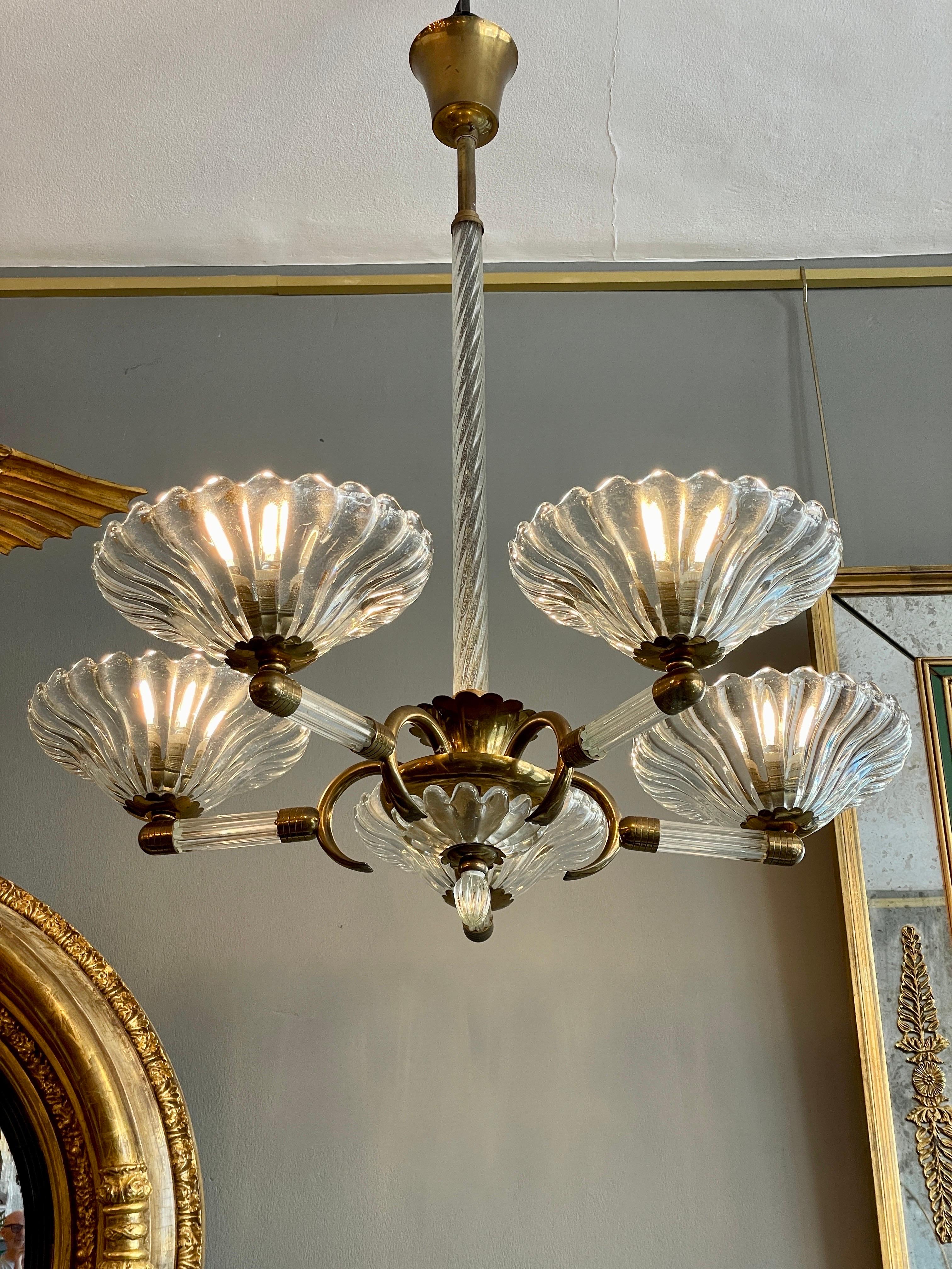 A good quality Murano glass and brass 5 arm chandelier by Barovier. The rope twist stem with glass and brass centre supporting 5 arms with wide dish shades.
Small damage to one shade on the inside of dish not visible when hung and imaged in slider.