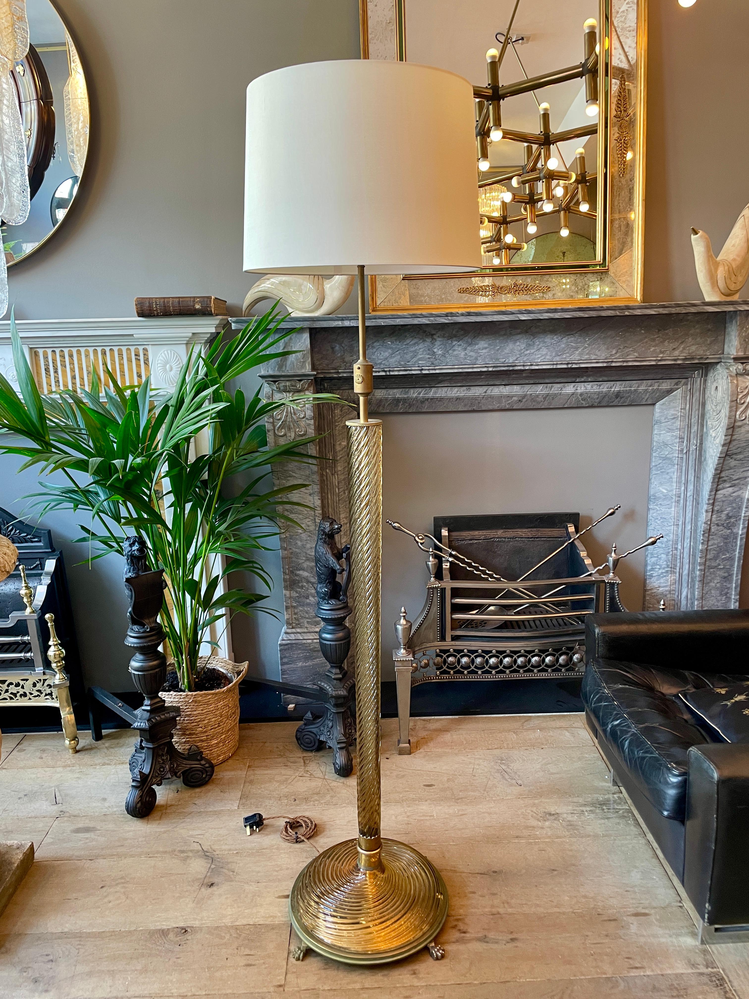 A very good quality Murano floor lamp in amber twist glass and Brass. The stem in a tapering twist with brass accents is supported with an amber twist Murano base sitting on a brass plate with lions paw feet. Re wired with gold silk flex and a new
