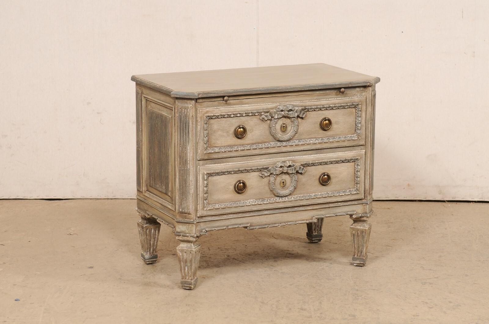 A vintage Neoclassic style painted wood two-drawer side chest from Italy. This small sized chest from Italy, circa late 20th century, is a very well made piece with lots of nicely carved details. It has been designed in Neoclassical influences; with