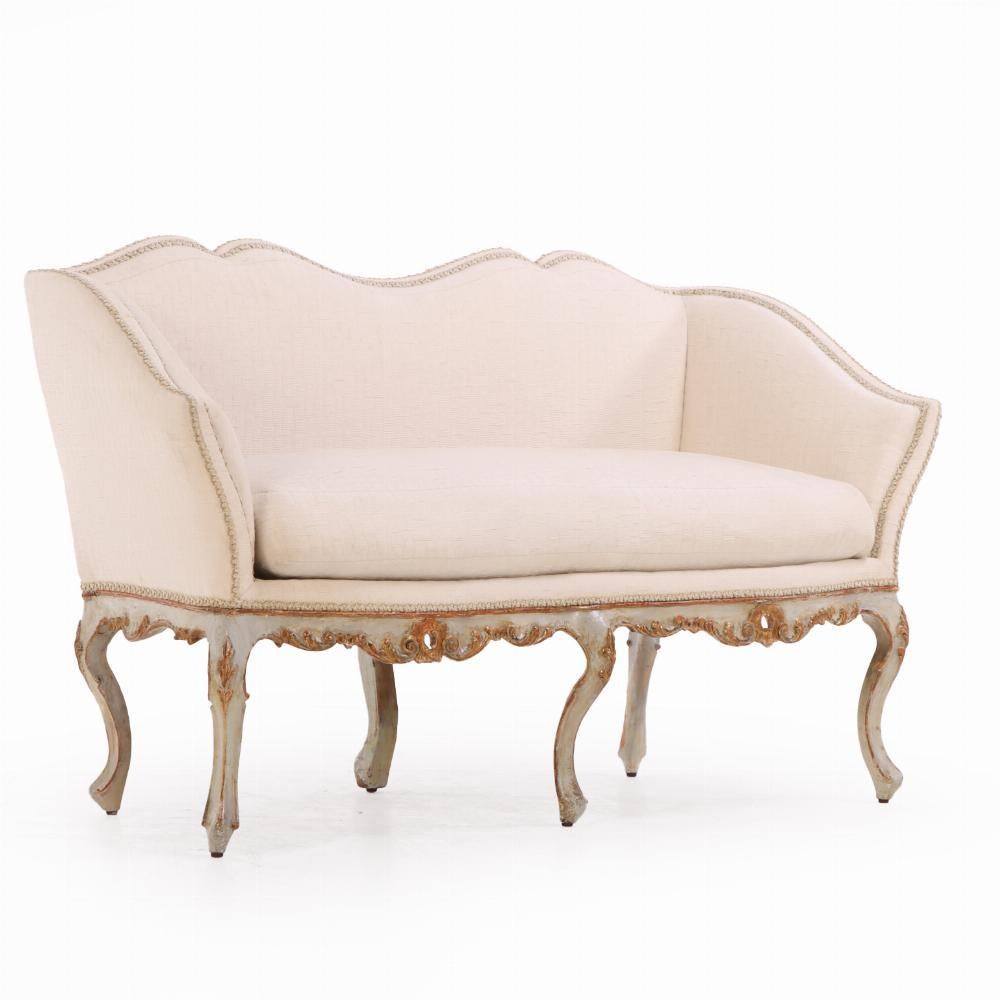 Upholstery An Italian painted and carved settee, 18th C., in recent fabric. For Sale