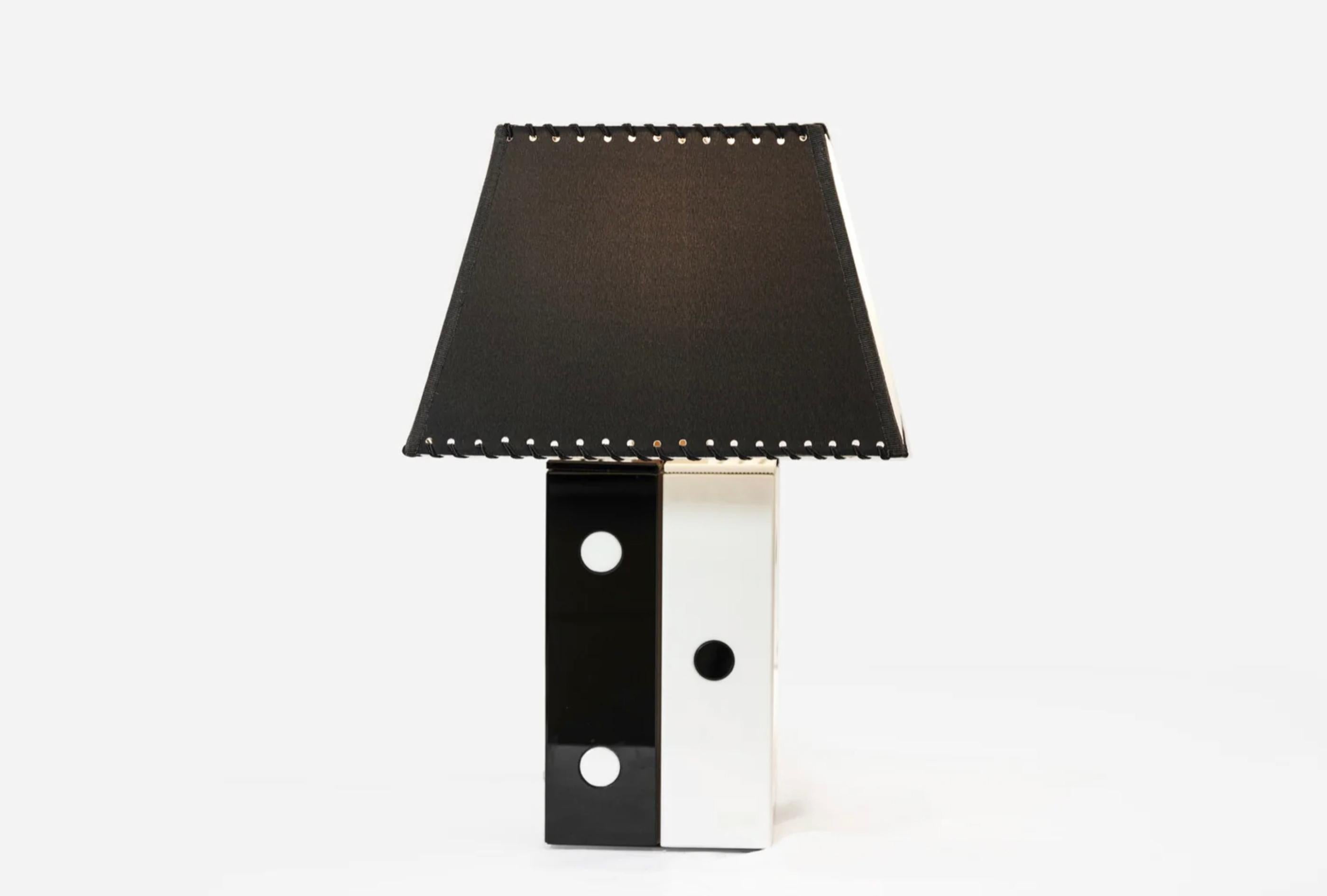 Cette paire de lampes de table, fabriquée en Italie vers les années 1960, reflète l'élégance raffinée ainsi que l'esprit moderniste et ludique du design italien du milieu du siècle dernier. Chaque lampe présente une base rectangulaire sculpturale en