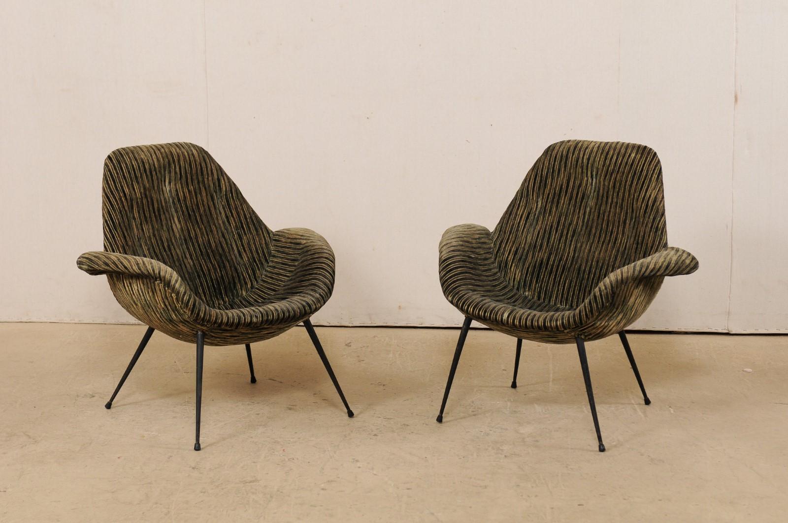 An Italian pair of modern design club chairs from the mid-20th century. This midcentury pair of armchairs from Italy are stylishly designed with scooped seats, nicely curved backs, and graceful arms which are a smooth transition between sides and