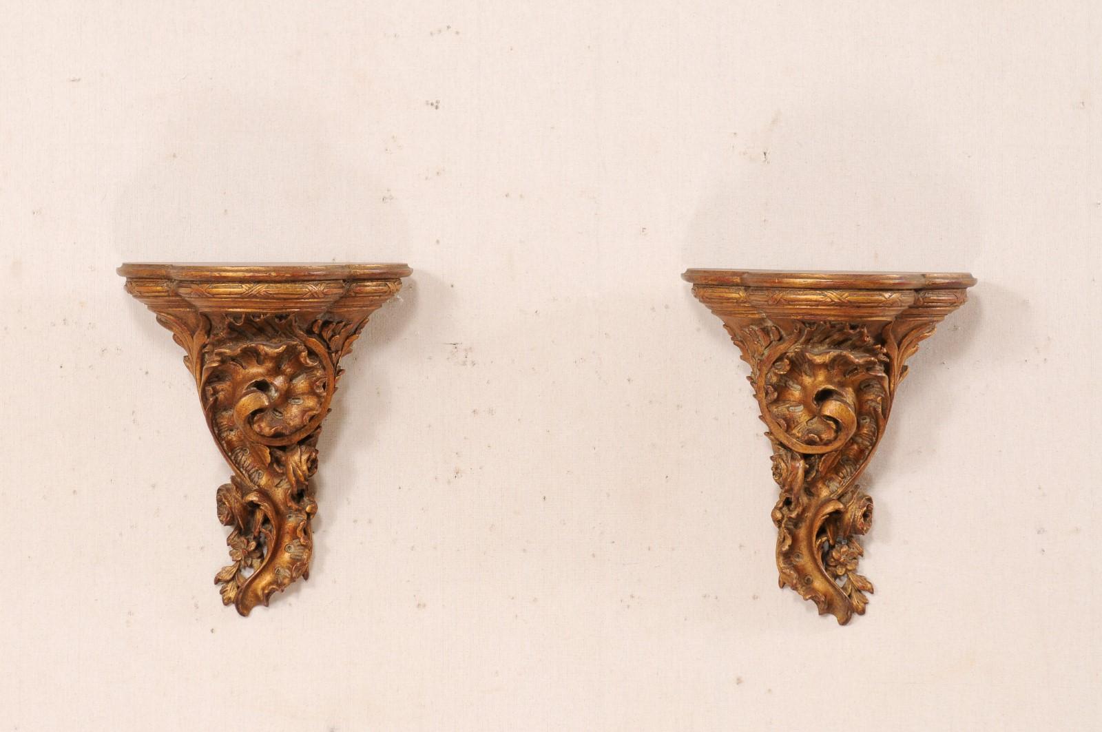 An Italian pair of carved-wood decorative wall shelves from the mid 20th century. These vintage shelves from Italy have been hand carved, in a swirling leaf motif. The shelf top has a rounded and molded edge, with curvy bowed front, and flat
