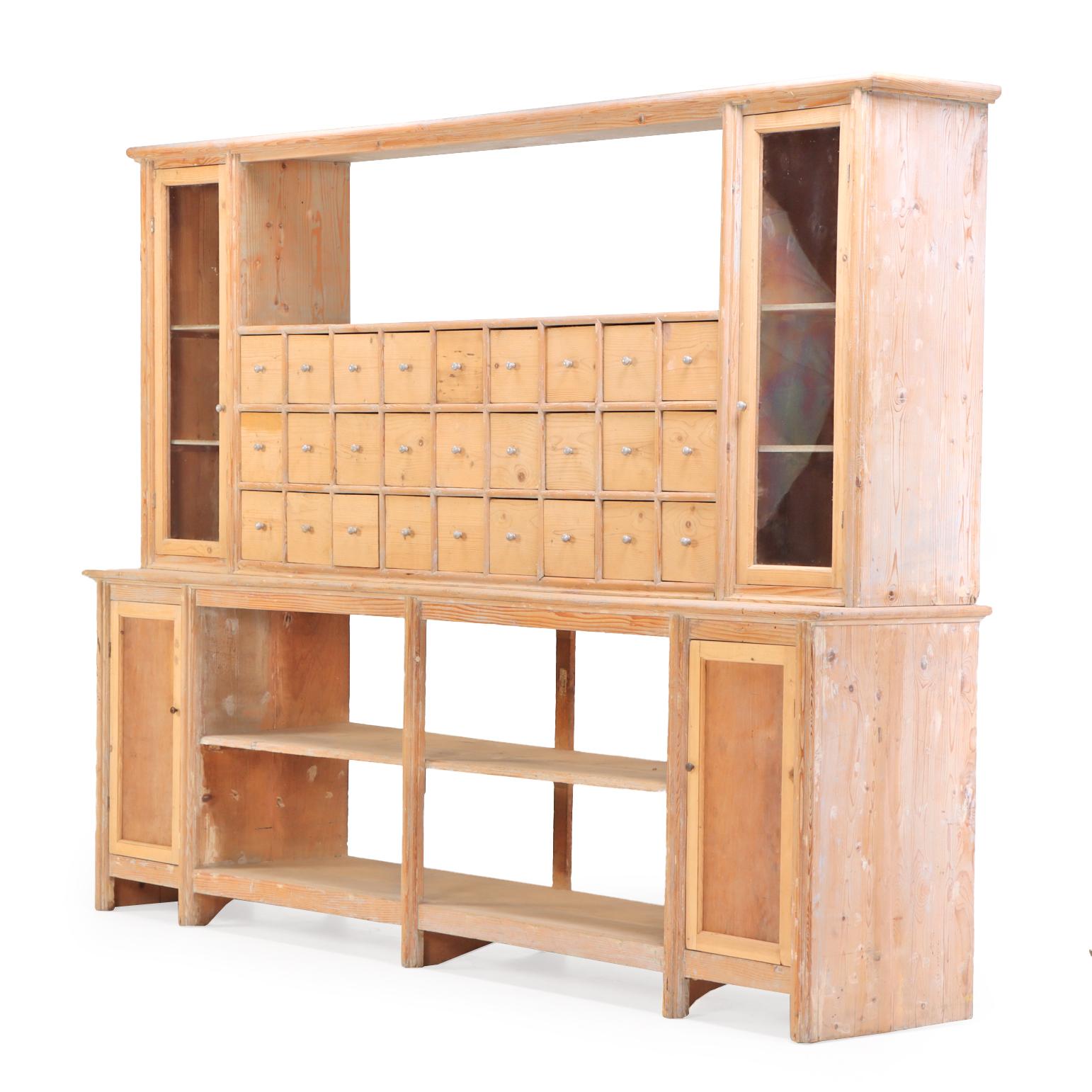 An Stauraum mangelt es diesem wunderbaren Schrank aus dem 19. Jahrhundert nicht! Im oberen Teil befinden sich zwei gläserne Schranktüren, die sich zu Regalen öffnen lassen, die ein offenes oberes Regal über drei Reihen von neun kleinen quadratischen