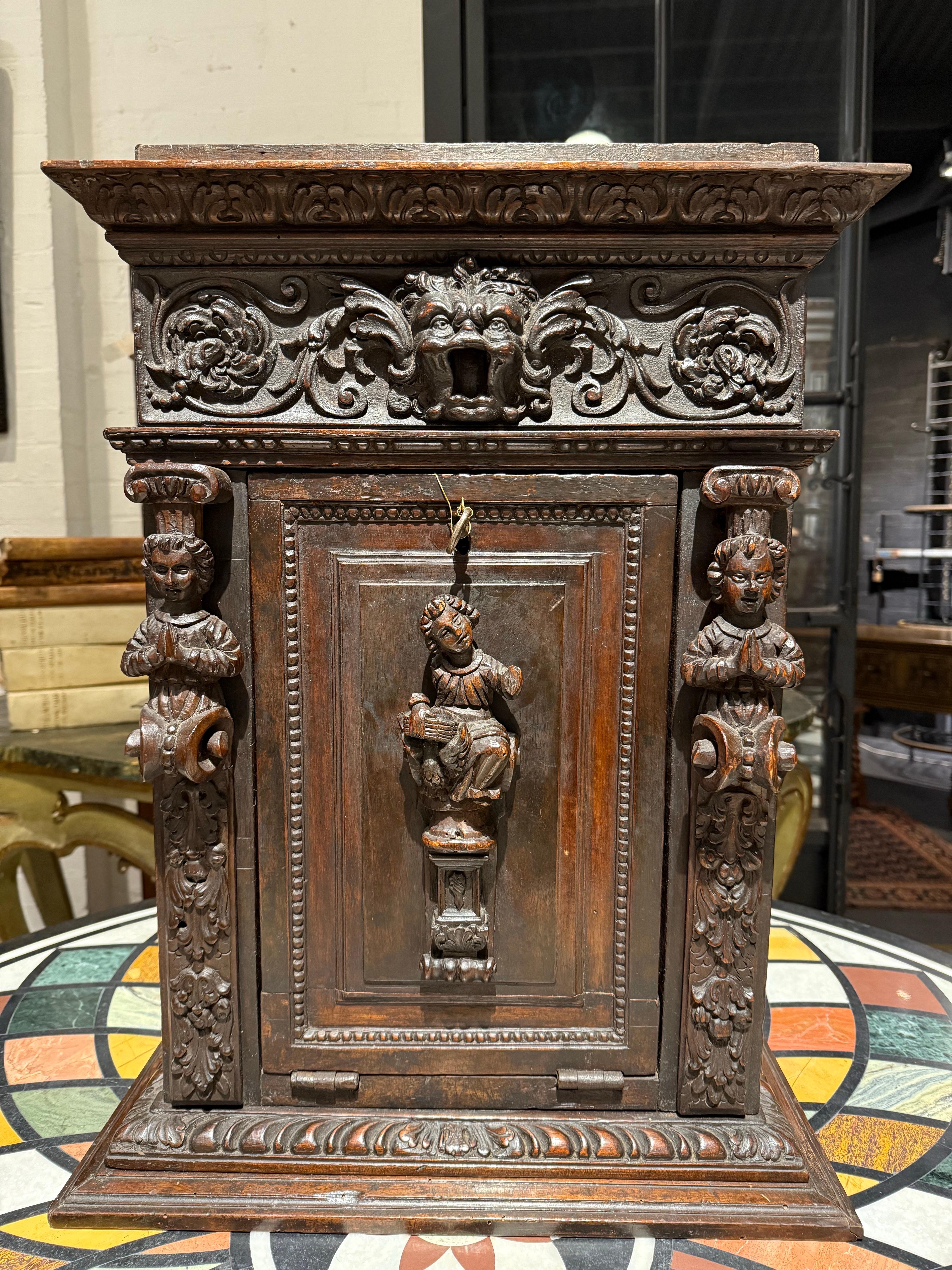 An Italian Renaissance Style Walnut Studiolo Cabinet, 17th Century

Description:
A renaissance style studiolo of architectural form in walnut, the exterior entablature with risen gallery fitting, over foliate cornice to further band of dart and