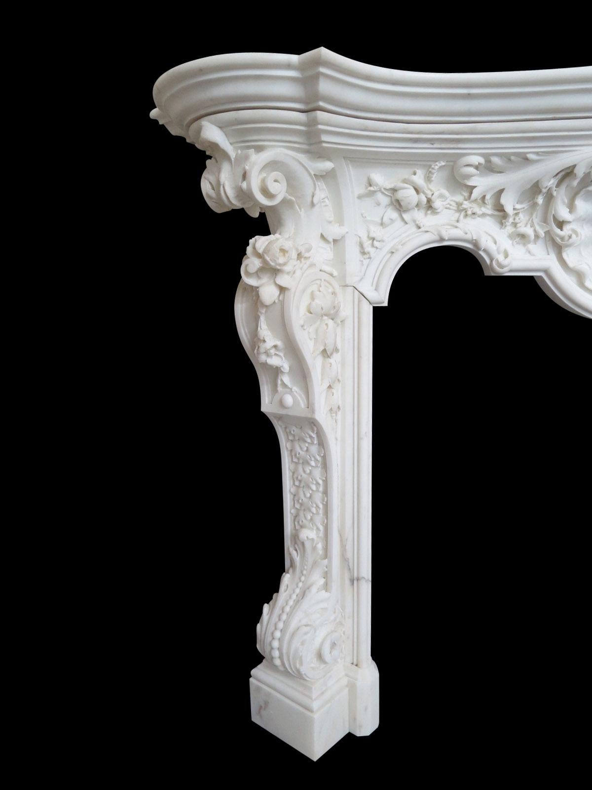 A mid 19th century Rococo revival chimney piece executed in superior Statuary white marble and profusely carved in high and low relief. The cantered jambs with large scrolled and beaded acanthus with a panel of carved oak leaf, surmounted by carved