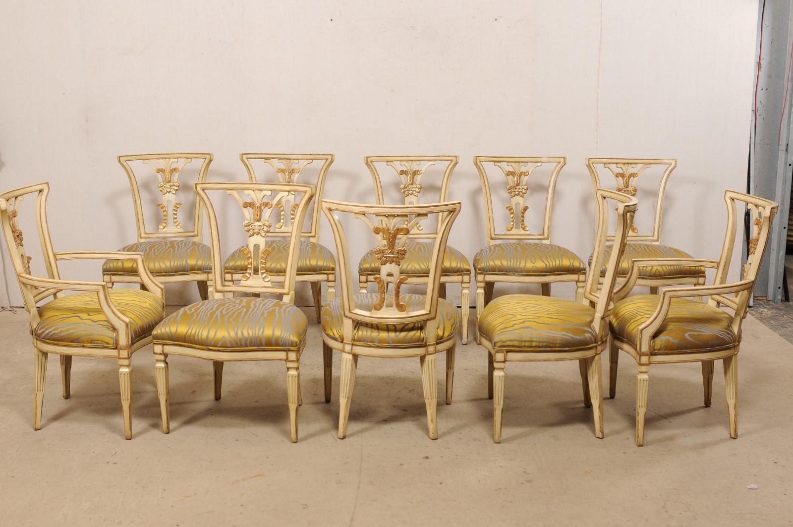 An Italian set of ten dining chairs, with carvings on both sides, from the mid 20th century. This complete set of ten vintage chairs from Italy, which includes two armchairs and eight side chairs, has been designed with neoclassical influences, and