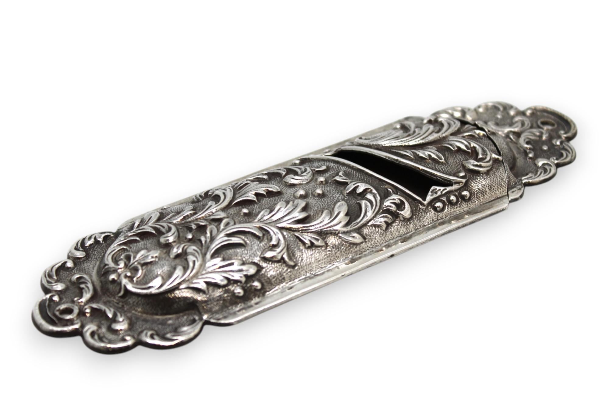 Questo squisito astuccio per Mezuzah in argento è uno straordinario esempio di arte barocca. Mostra elaborati motivi di fogliame in alto rilievo. Realizzato con dettagli intricati, i fluenti disegni fogliacei sono splendidamente cesellati sul