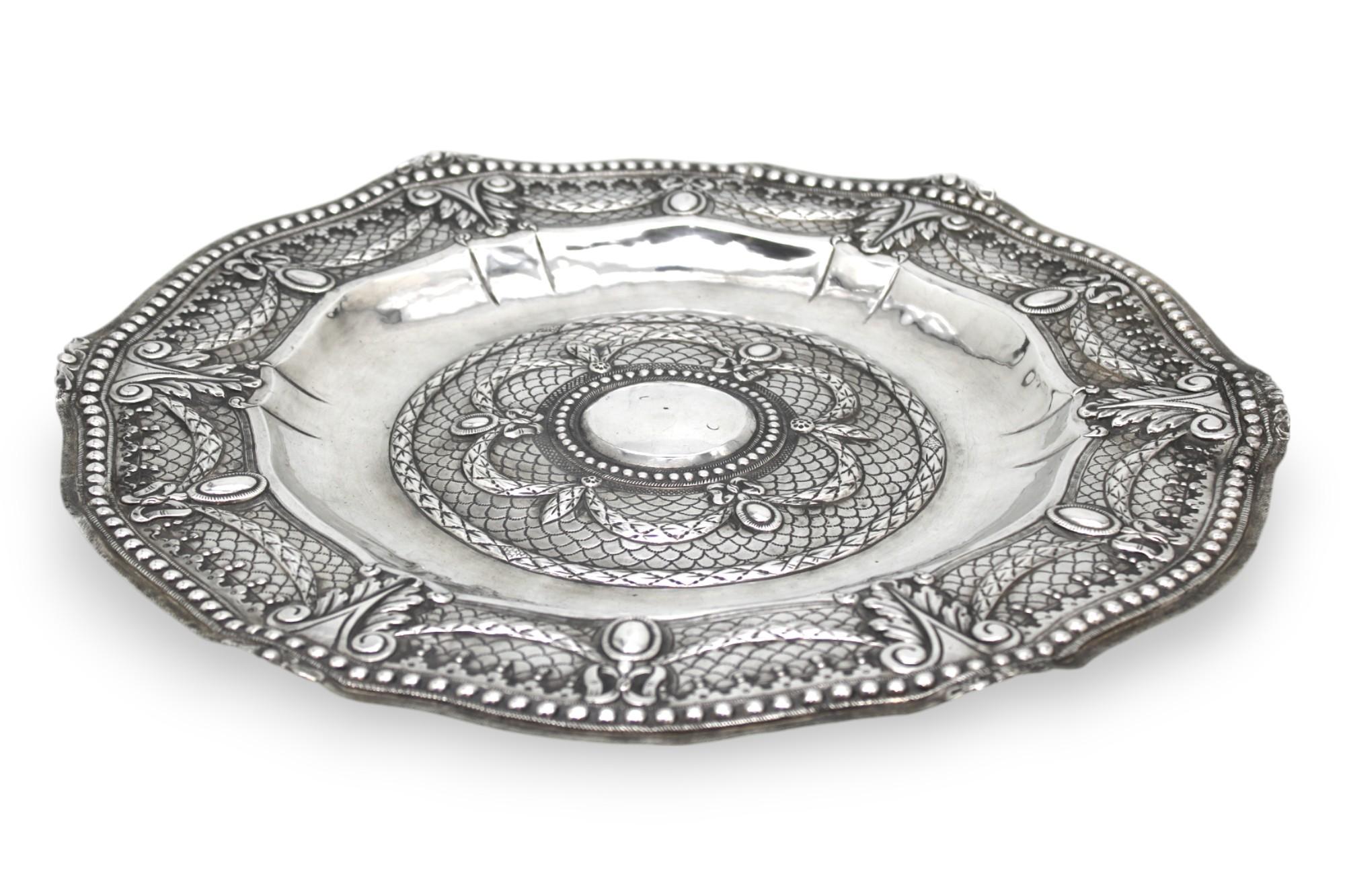 This magnificent Italian silver Passover Seder plate, crafted in Venice circa 1800, is a striking example of refined silversmith artistry combined with deep ritual significance. Made entirely of finely worked silver, the plate features a broad,