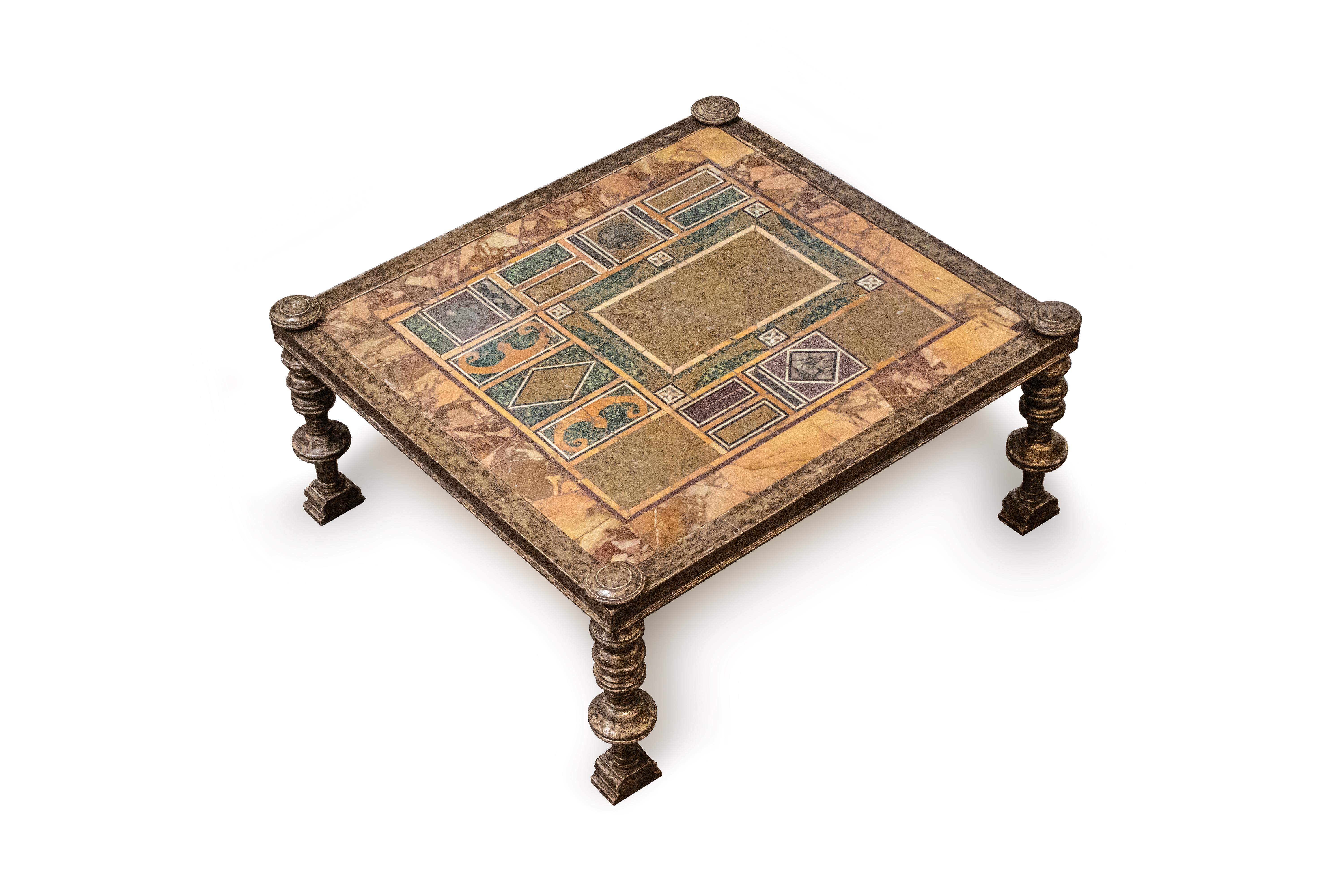 A low occasional table on silvered wood frame and carved feet. Each corner has a detachable carved ending, made of the same wood as the frame.

The rectangular tabletop is a hand-crafted marble inlaid panel. Each fragment shows different