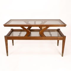 An Italian teak two tier coffee table with wavy glass supports