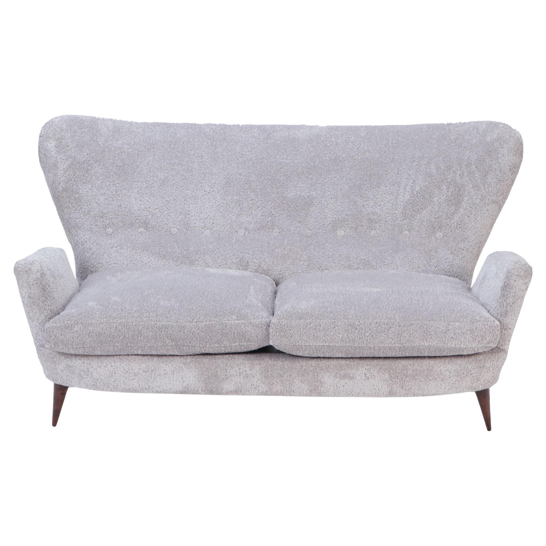 An Italian vintage wingback drop arm upholstered settee.