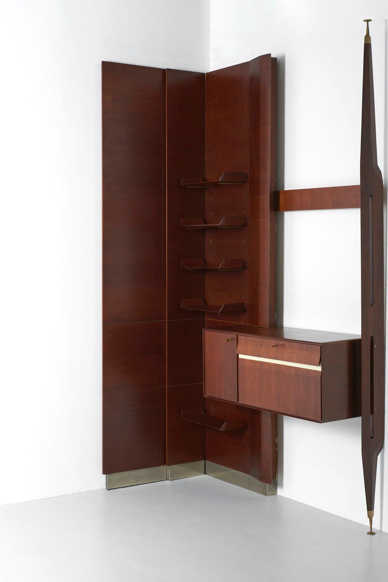 An Italian wall unit with shelves and a cabinet. The supports of the shelves are in solid brass. The height of the panels is 303cm, the endcaps of the pole can be adjusted in height. The system should be fixed to the wall, therefore it can be placed