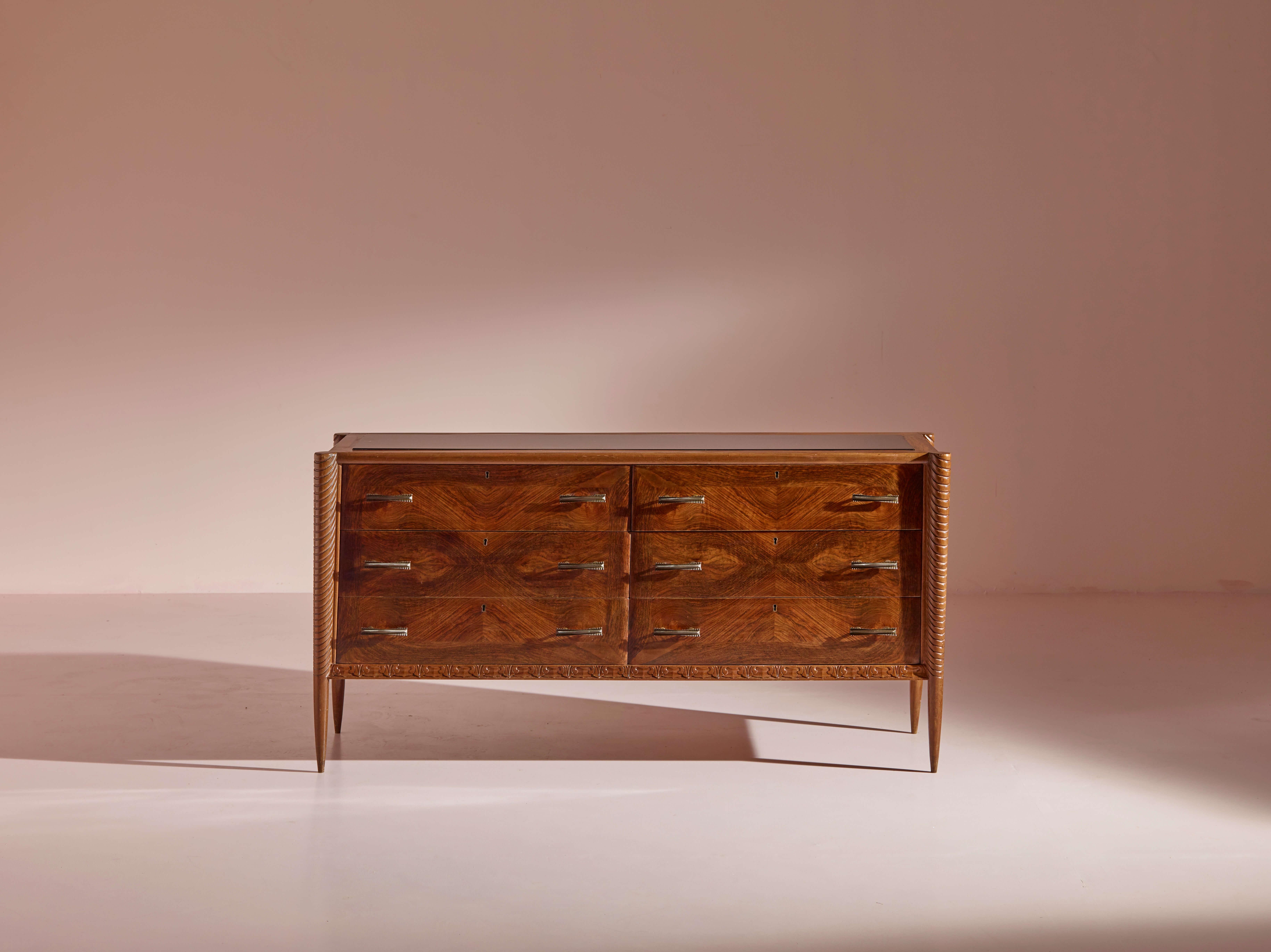 A rare and beautiful mid-century modern Italian chest of drawers, crafted in the style of Paolo Buffa, stands as a testament to the timeless elegance of 1940s Italian design. Made from rich African walnut, this exquisite piece exudes a sophisticated