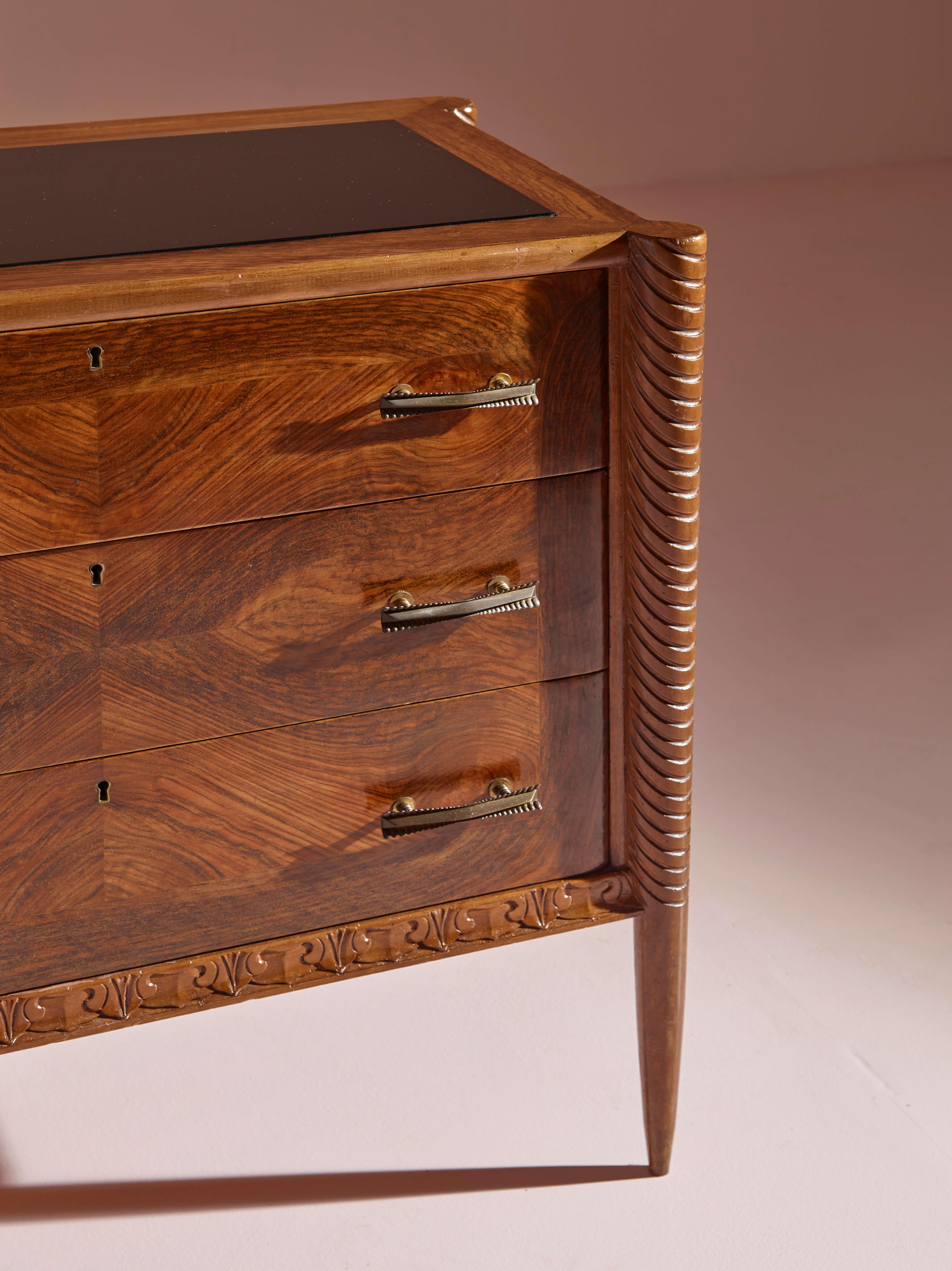 Mid-Century Modern An Italian walnut sculpted chest of drawers with black glass top from the 1940s