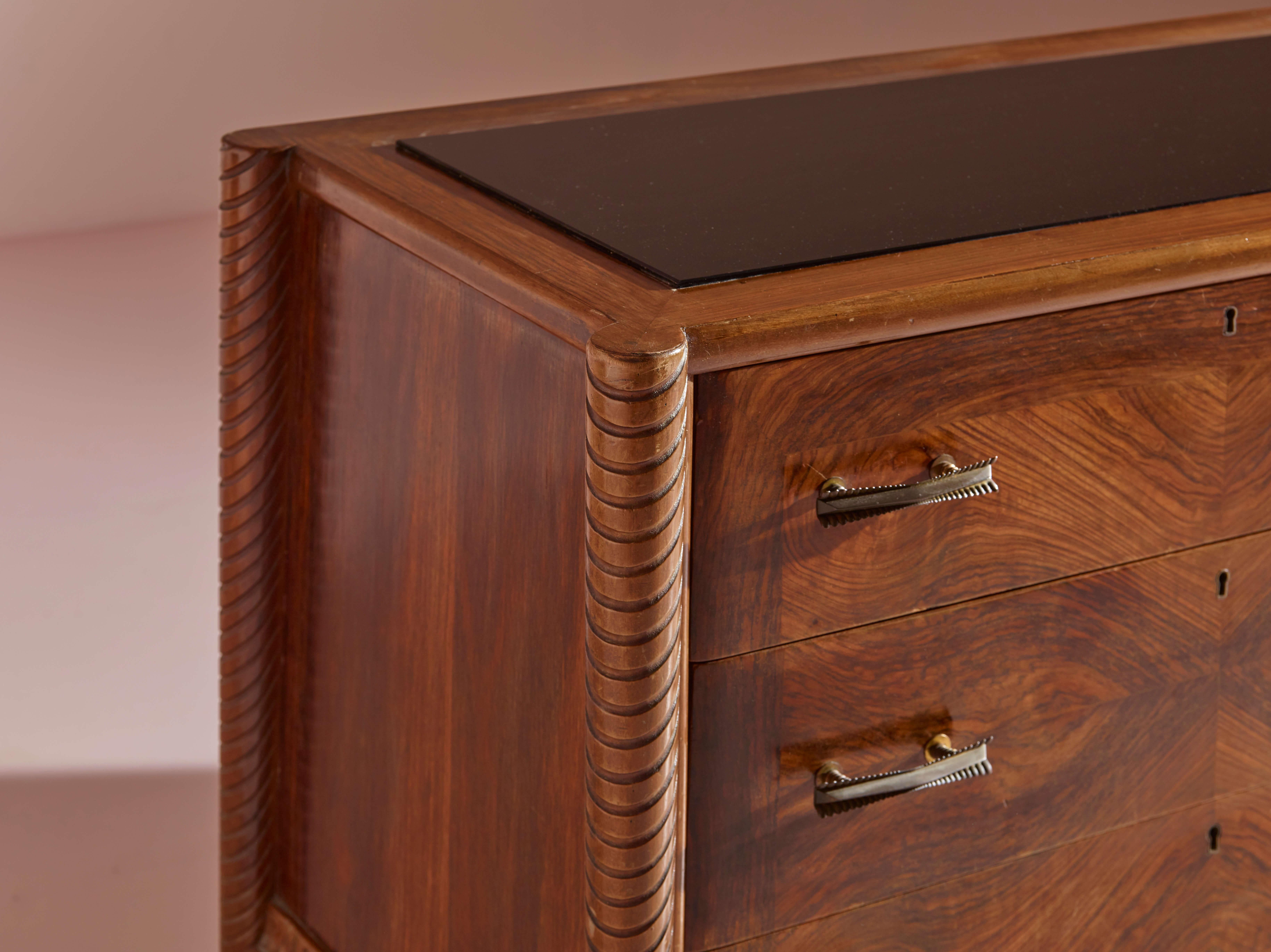 Carved An Italian walnut sculpted chest of drawers with black glass top from the 1940s