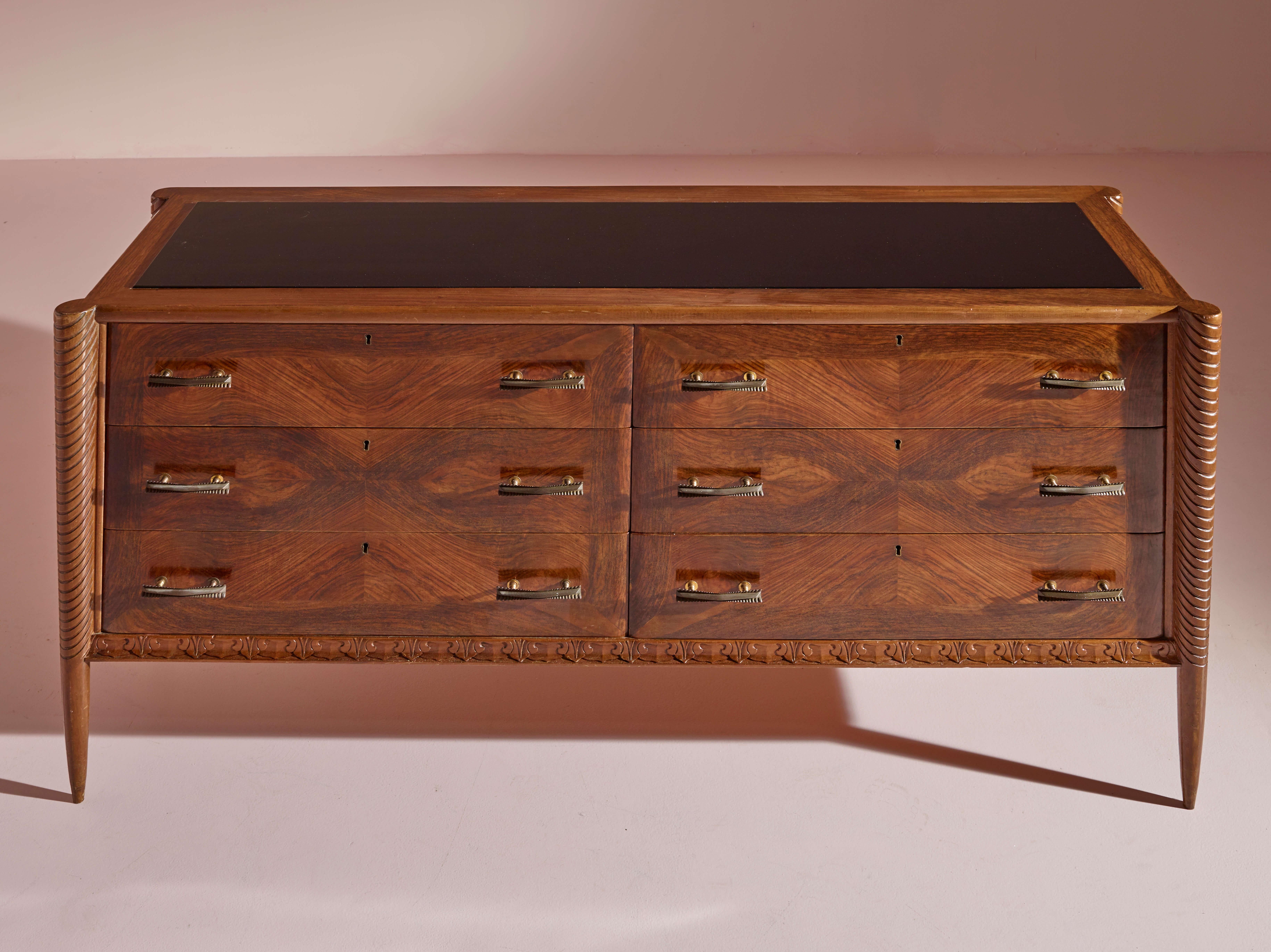 Mid-20th Century An Italian walnut sculpted chest of drawers with black glass top from the 1940s