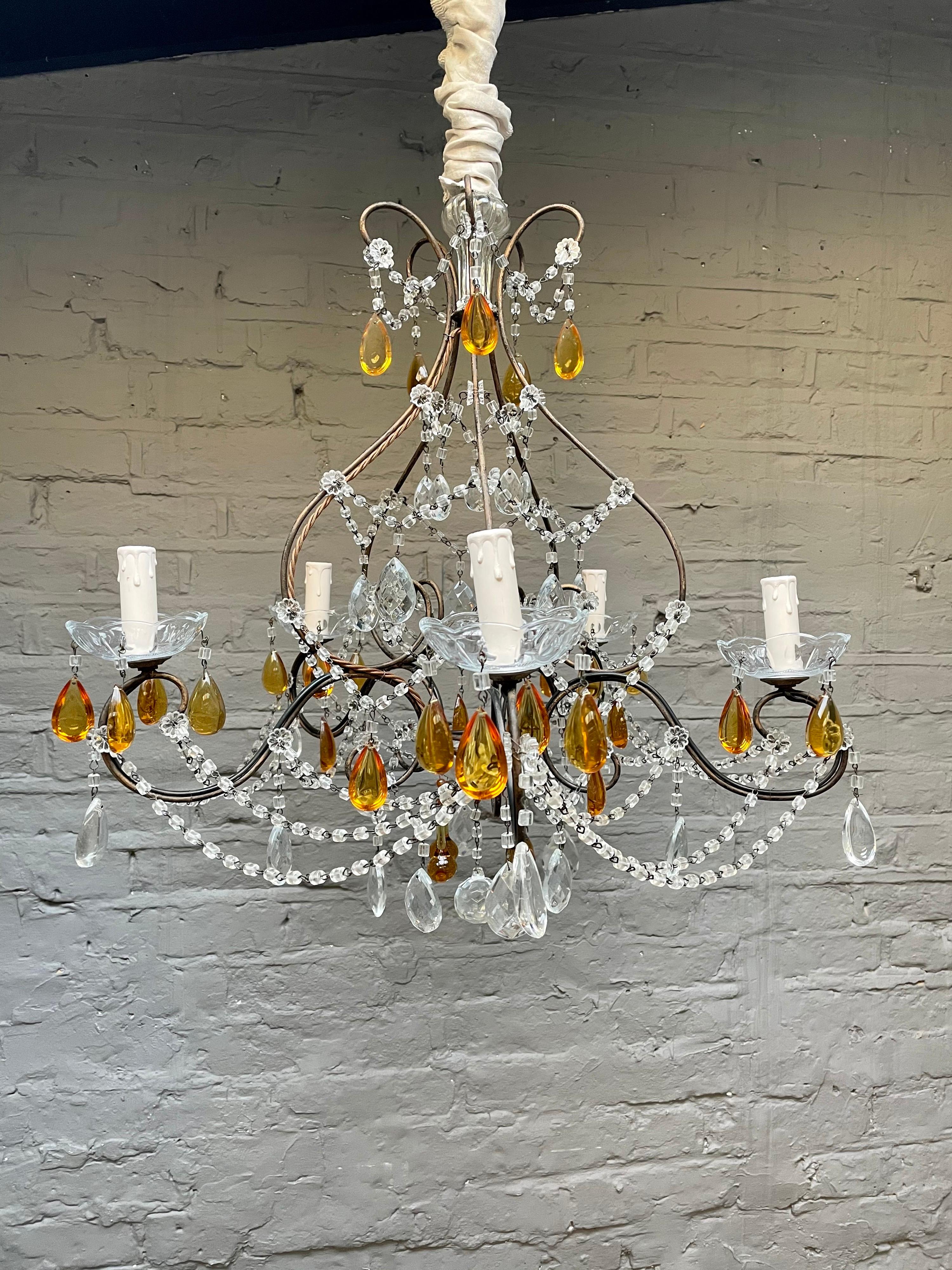 A pretty wrought iron and glass chandelier, with scrolled arms clear and amber glass drops with strung beading, early to mid-20th century, Italian.