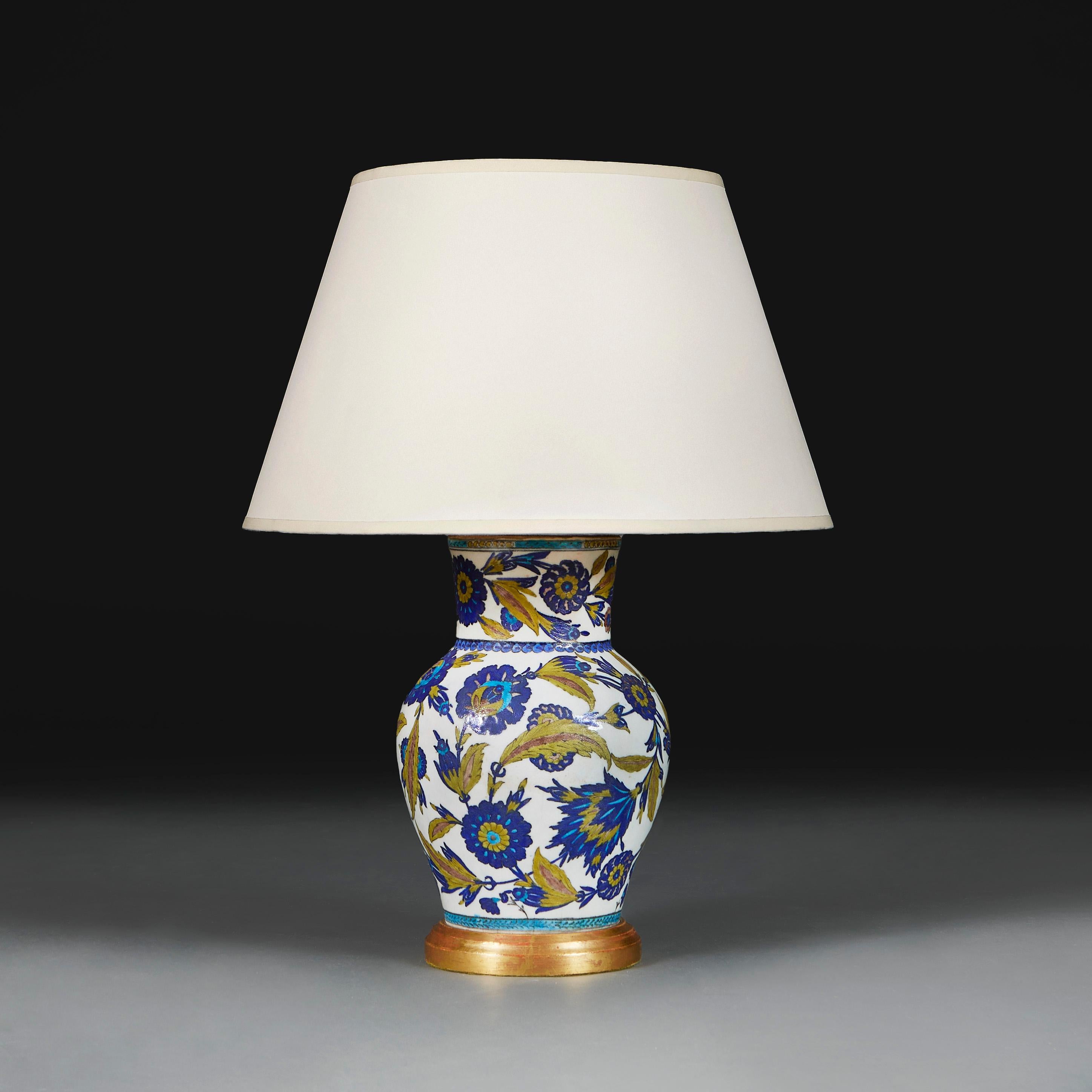 Italien, um 1890

Vase aus dem späten neunzehnten Jahrhundert, verziert mit Arabesken aus grünen Saz-Blättern  und blauen Nelken auf weißem Grund, jetzt umgewandelt in eine Lampe mit vergoldetem Sockel. 

Höhe der Vase 30.00cm

Höhe mit Schirm