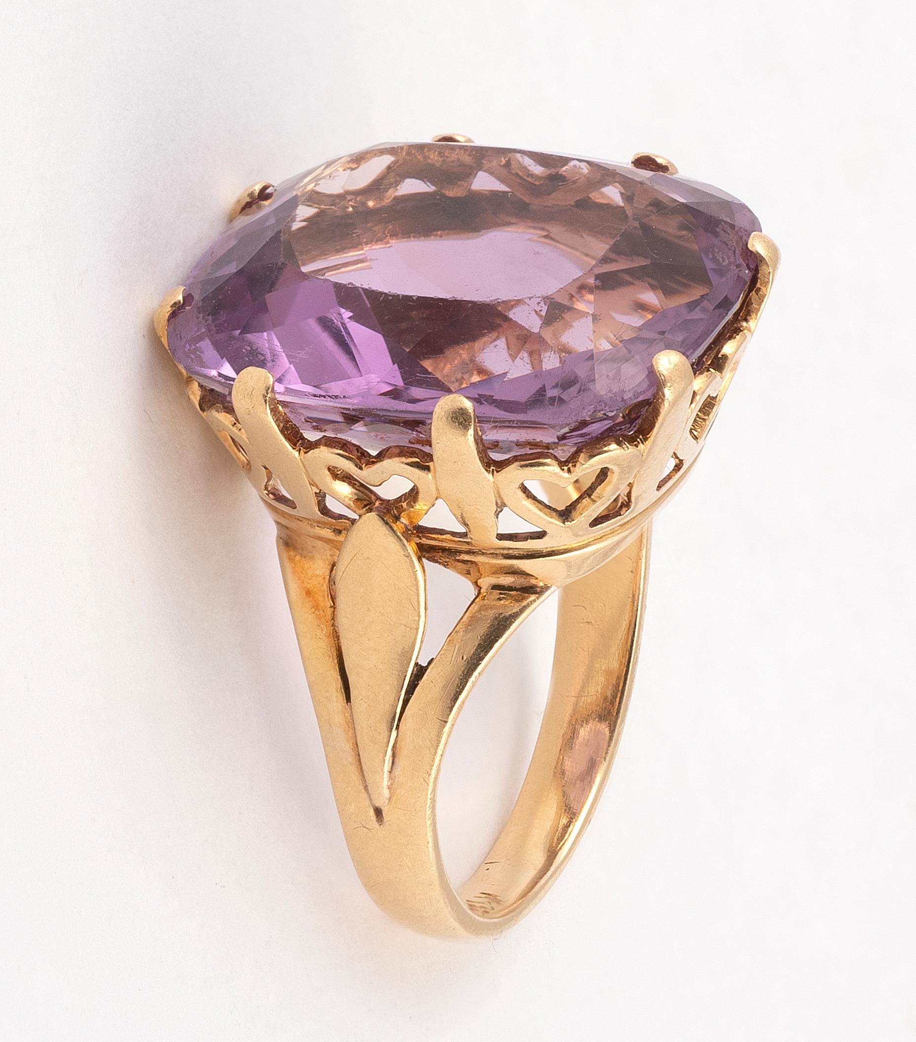 The cushion-shaped mixed-cut amethyst in a claw-setting, the openwork mount and band composed of heart wirework, ring size 7