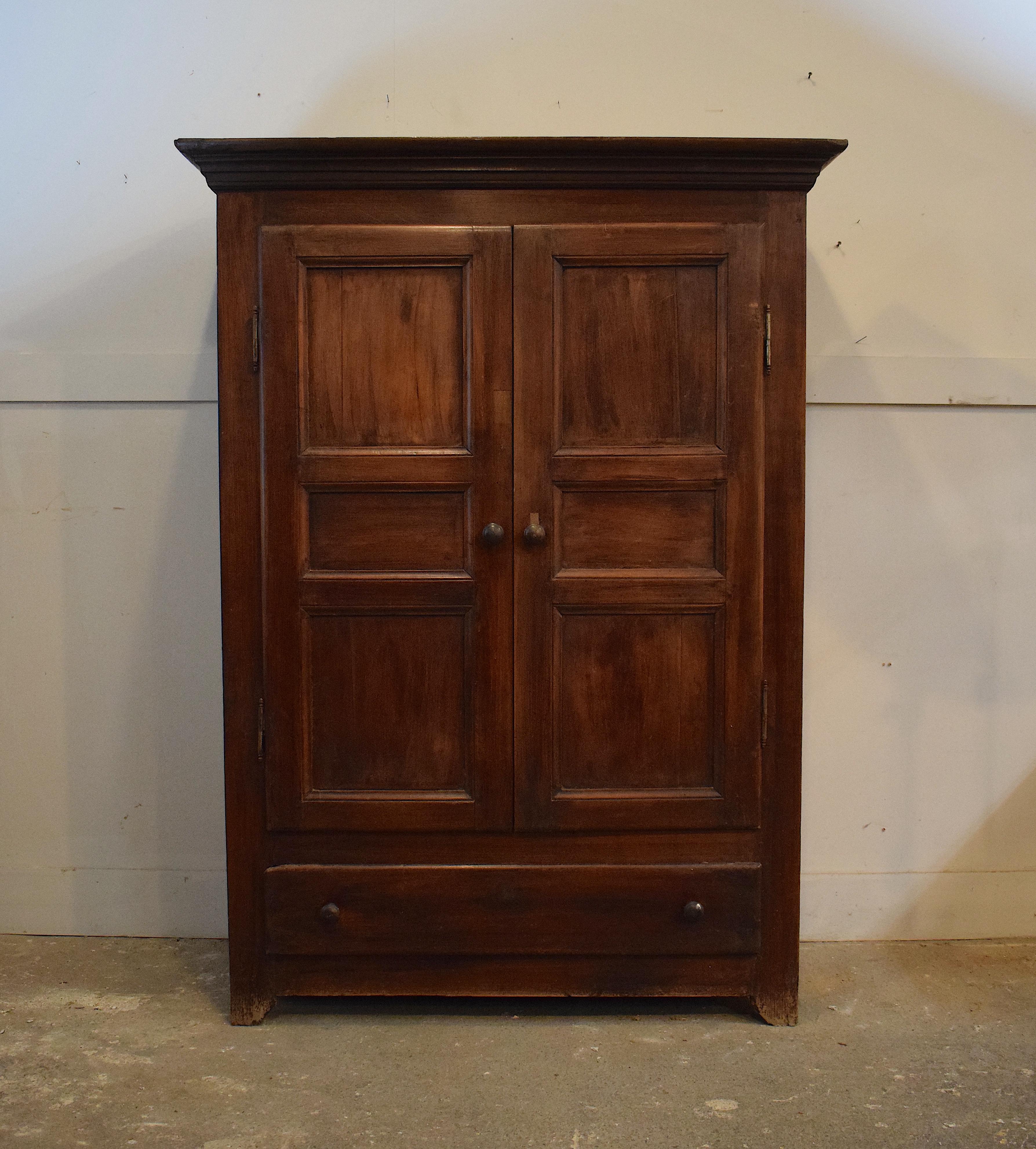 An antique French solid walnut wardrobe made around 1850. It is rustic in its structure and it is traditional to the furniture produced during the Louis Philippe period which reflected a simplicity in its design compared to previous periods in