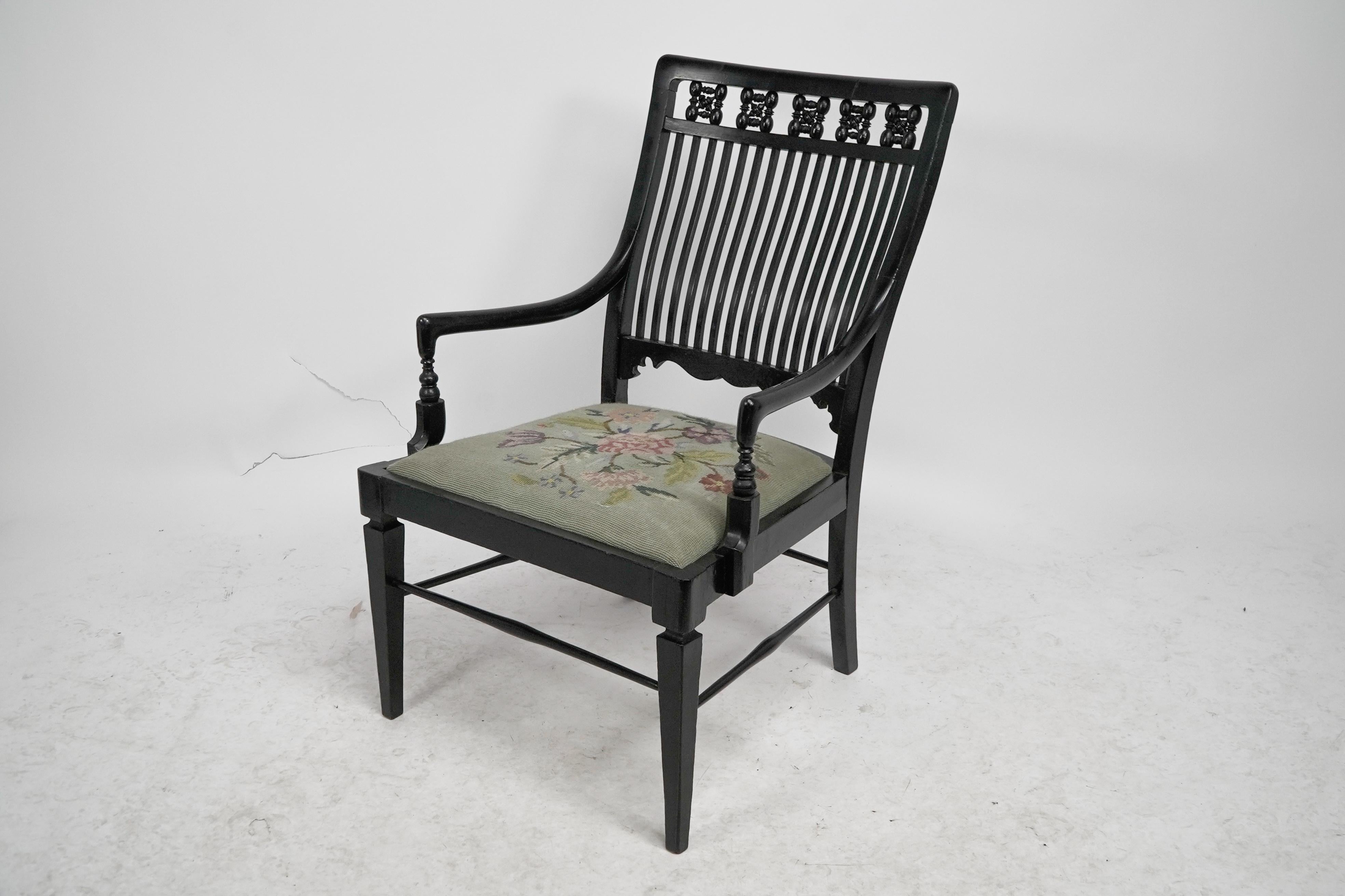 English Liberty & Co armchair with a shaped back & mashrabiya turnings to the head rest. For Sale