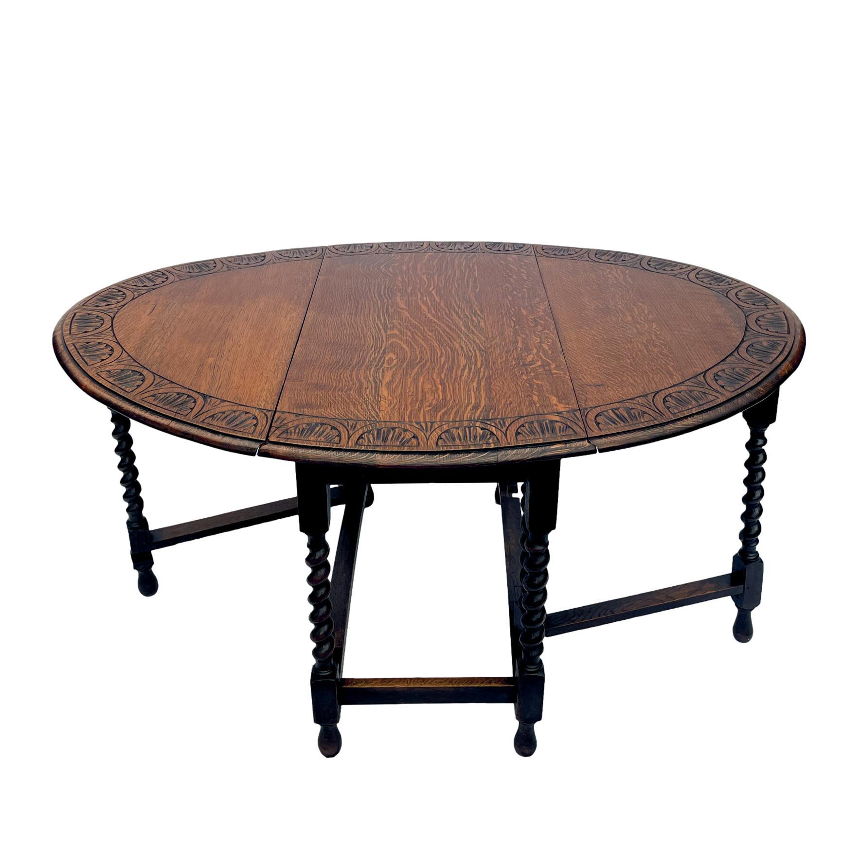 An Oak Barley Twist Dropleaf Gateleg Table with a carved and notched stylized band, English, circa 1920. A beautiful and highly functional table.