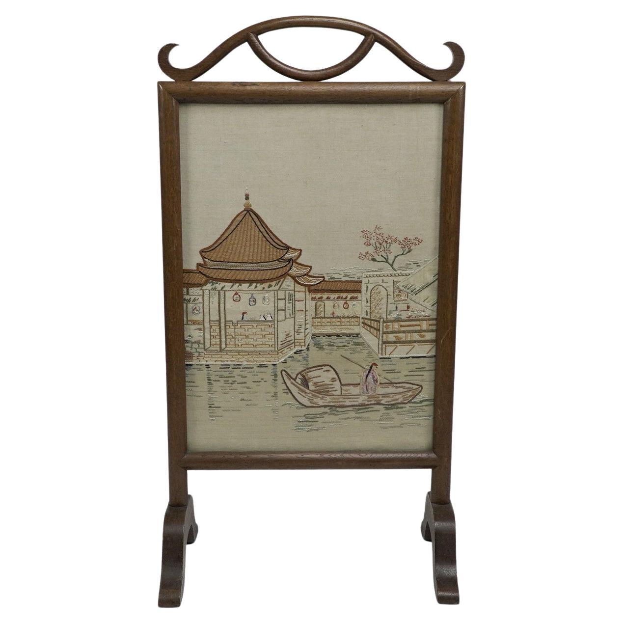 Anglo-Japanese oak firescreen with a Torri gate detail & embroidery river scene.