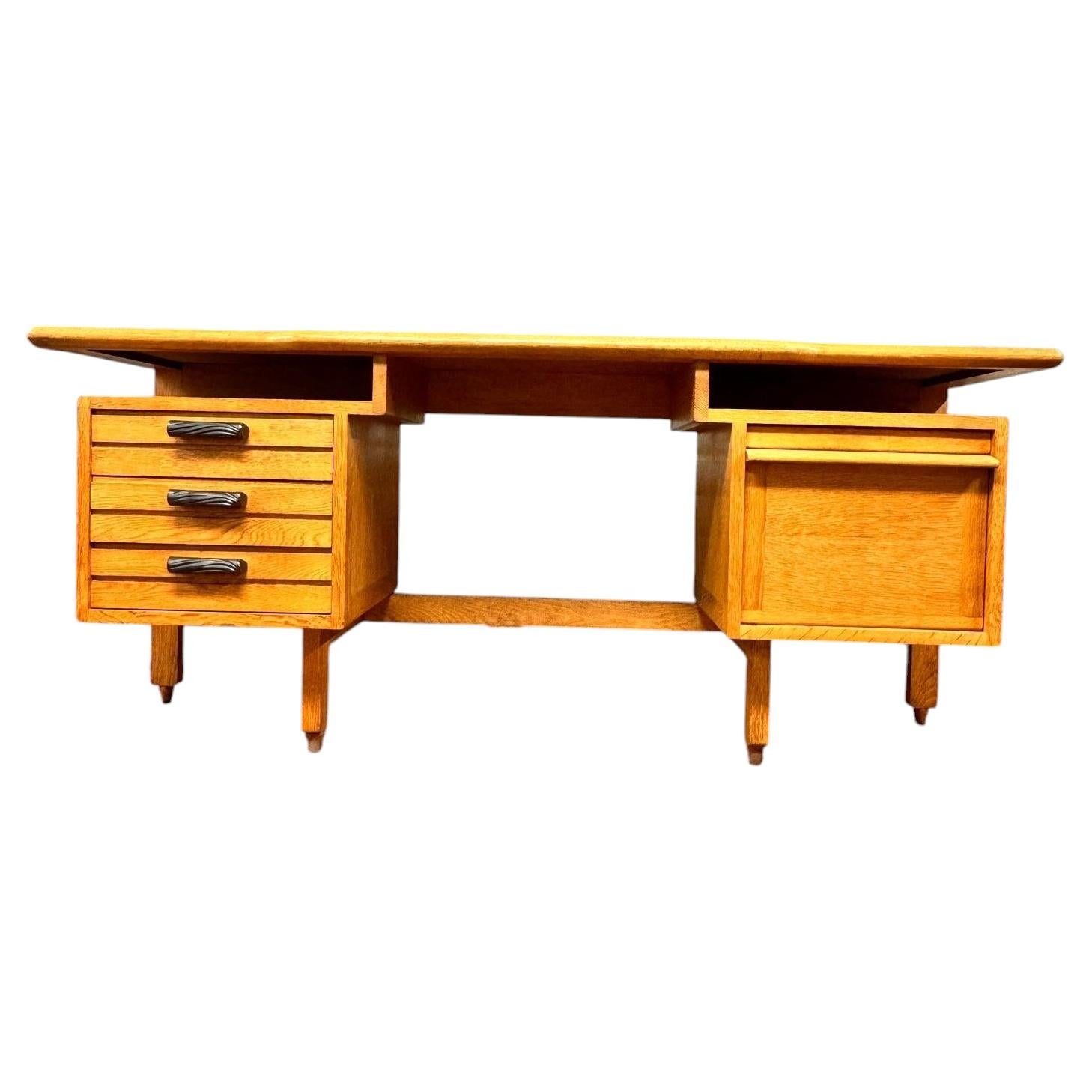 An oak Guillerme et Chambron desk with ceramic handles