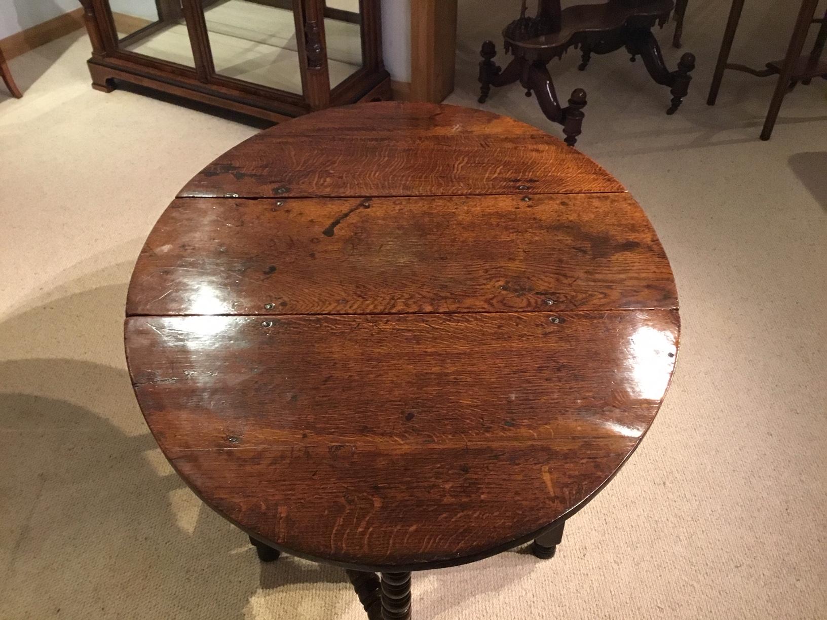An oak late 17th century bobbin turned gate leg dining table. Having an oak top of oval form with twin drop leaves of wonderful color and patination, supported on bobbin turned gate leg supports with further bobbin turned supports to the end, of