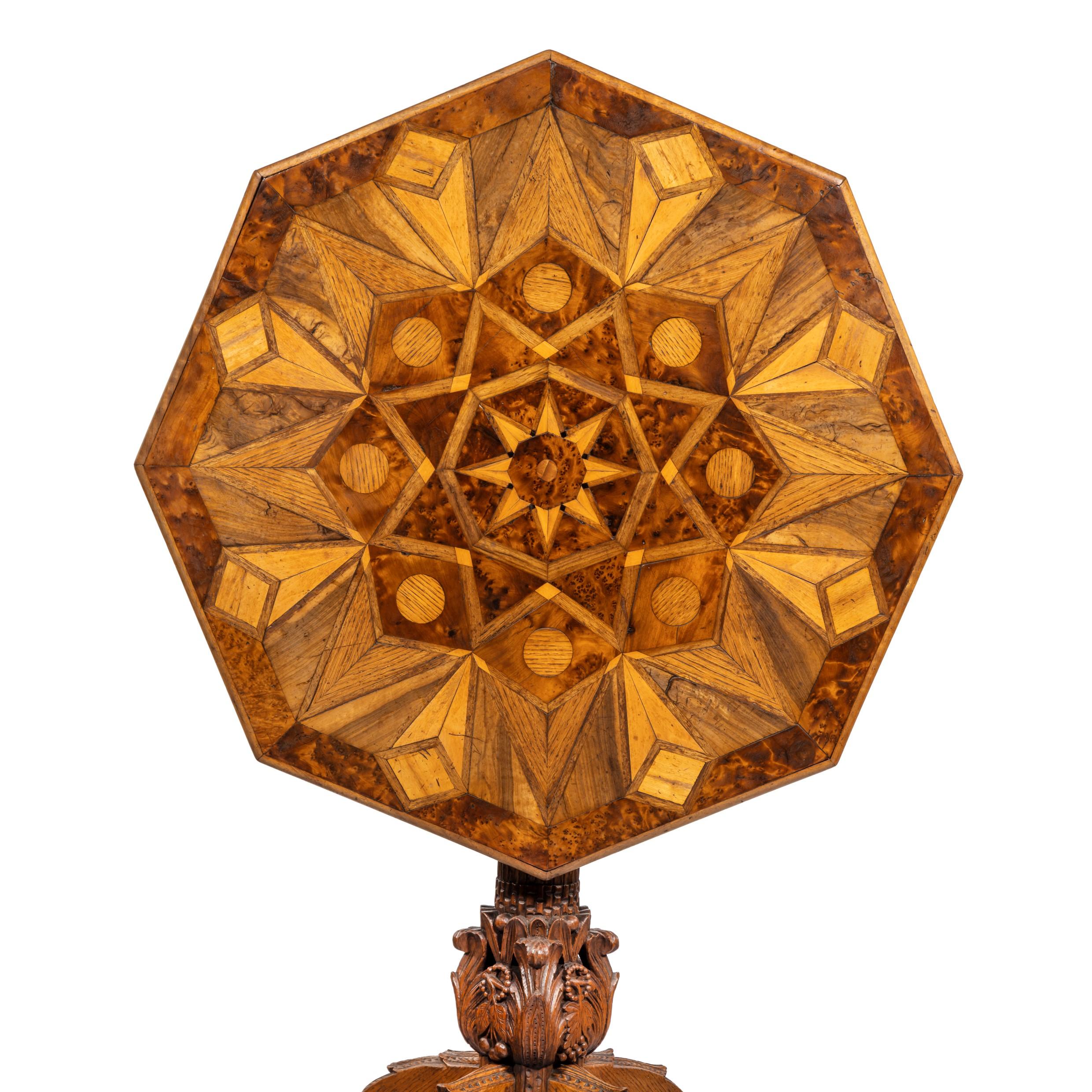 Une table octogonale en marqueterie de bois indigène, le plateau incliné incrusté sur les deux côtés de triangles et de diamants dans un motif en étoile, les bois comprennent l'if, le chêne et l'orme, sur une base de colonne classique sculptée avec