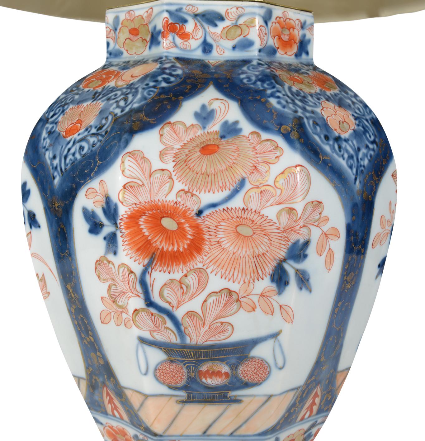 Un grand vase octogonal japonais Imari du début du XVIIIe siècle, décoré dans la palette typique Imari de bleus et de rouges de fer avec des reflets dorés sur un fond blanc, les panneaux étant magnifiquement peints de vases fleuris de chrysanthèmes