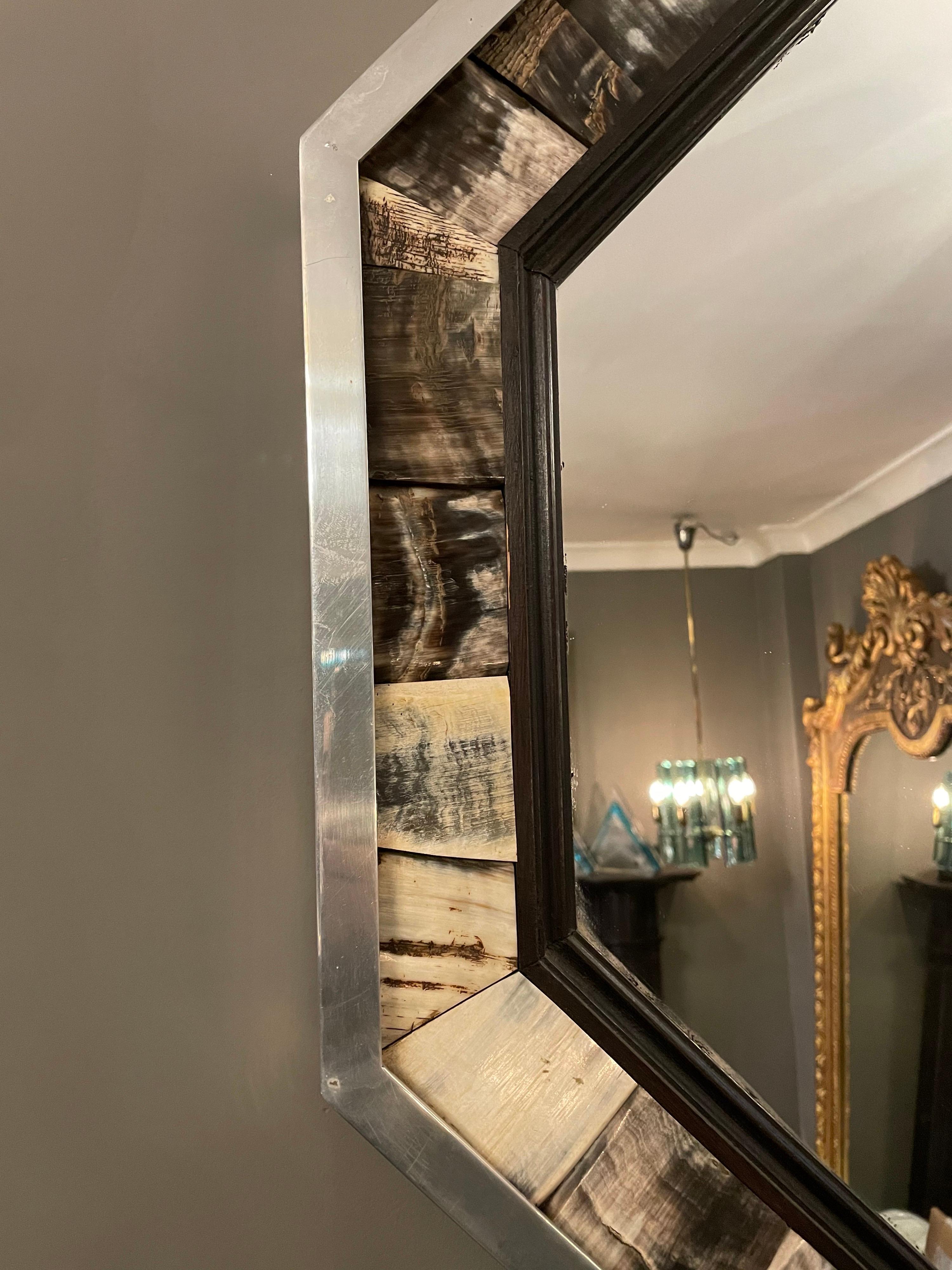 Un miroir octogonal en aluminium poli et corne, par le designer londonien d'avant-garde Anthony Redmile. Connu pour utiliser des matériaux naturels pour ses créations, celles-ci sont vibrantes et souvent excentriques.
