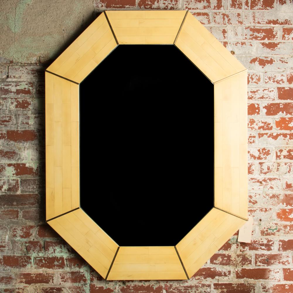 An octagonal mirror with tesselated stone mosaic decoration and brass details, American, circa 1975.
  