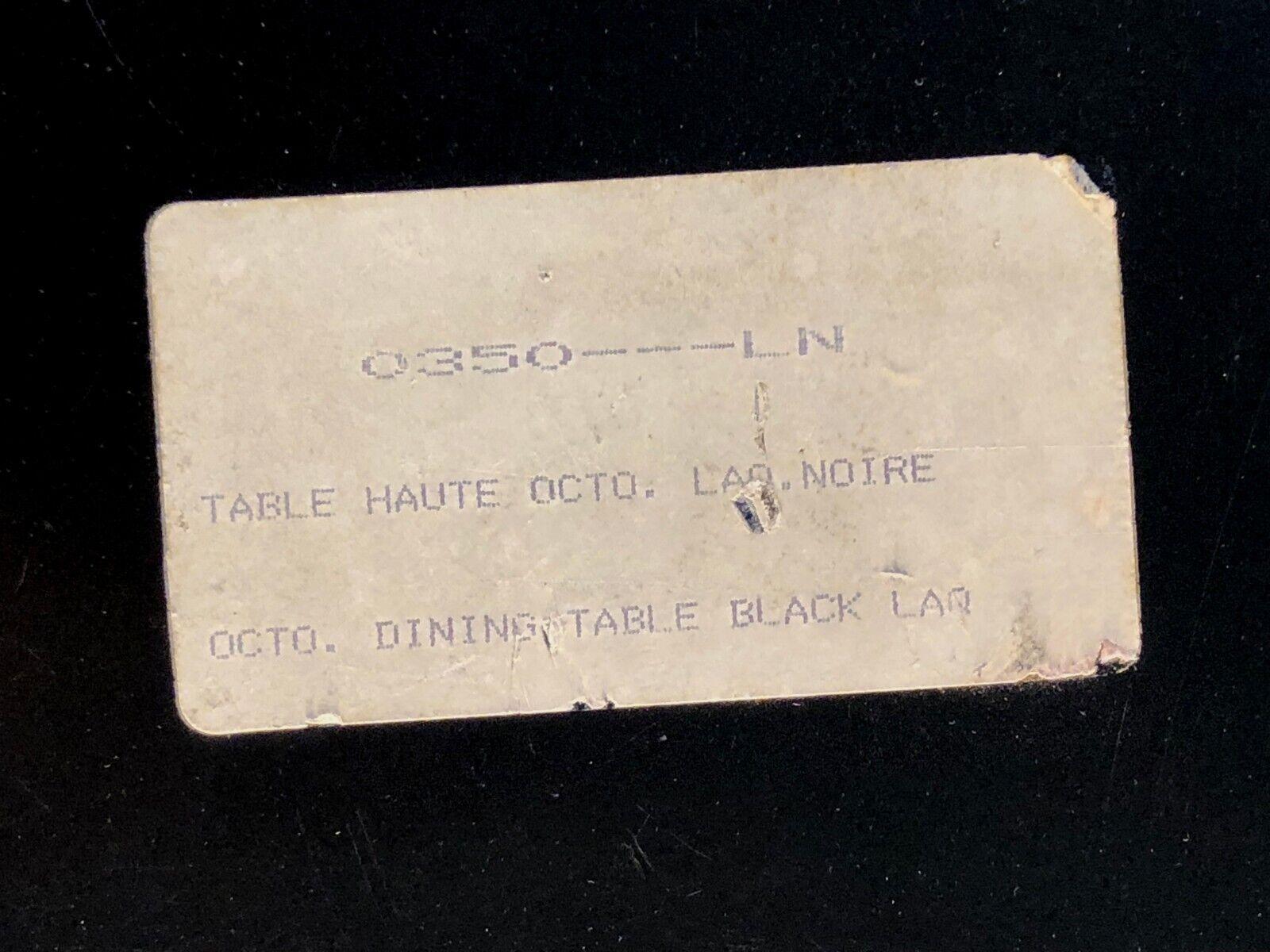 Ein sehr schicker und beeindruckender oktogonaler Esstisch, auf einem oktogonalen Sockel aus schwarz lackiertem Holz, mit einer Platte aus schwarzem Plexiglas, die von einem goldenen Gürtel aus Bronze oder Messing umspannt wird, signiert mit einer