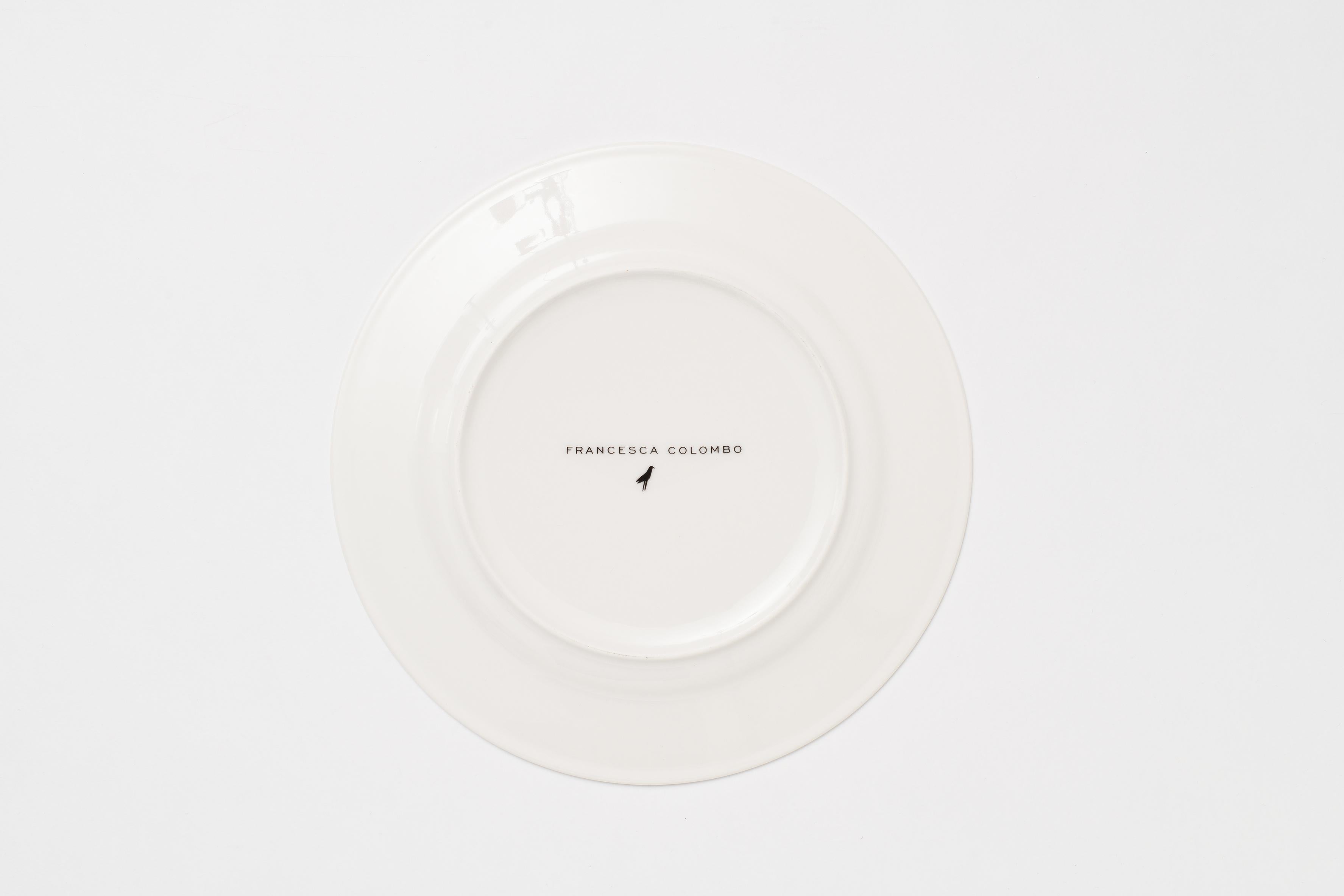 A bison, a typical animal of the woods is gently painted on this dinner plate, with soft black tones and it is surrounded by a delicate and intriguing mix of wild flowers and leaves reinterpreted in a fresh and poetic color way. These porcelain