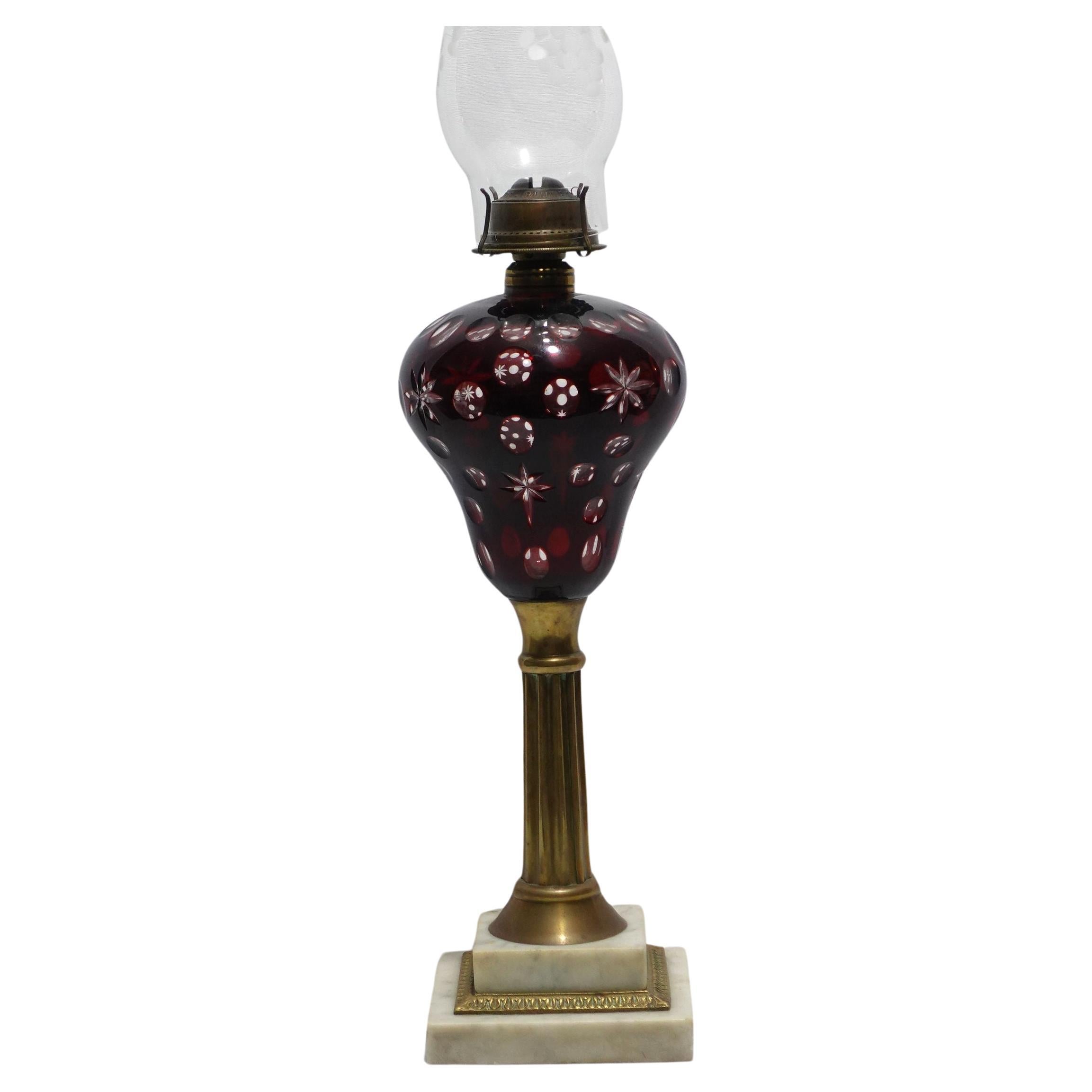 Eine alte Cranberry Cut To Clear Fluid Lampe mit einer klassischen Form A einer Säule auf einem Marmorsockel. 22 1/2