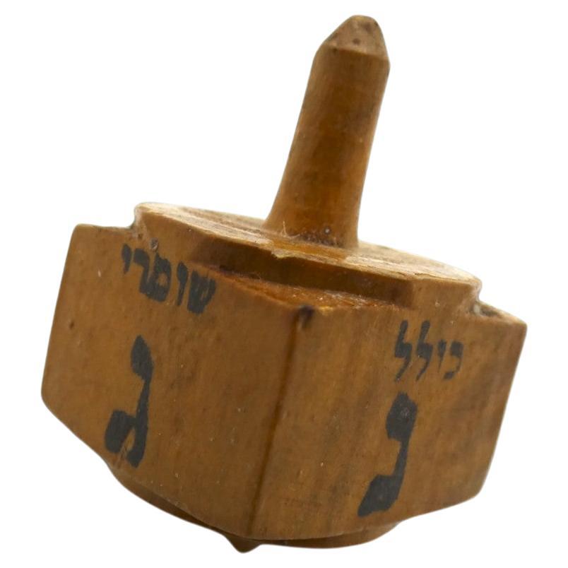 An Olivewood Dreidel made for the Kollel Shomrei HaChomot in Jerusalem Circa 1920.

Kollel Shomrei HaChomot is a financial charity institute set up to support the community of Hungarian-Jews who emigrated to the Holy Land. The Hungarian Jews
