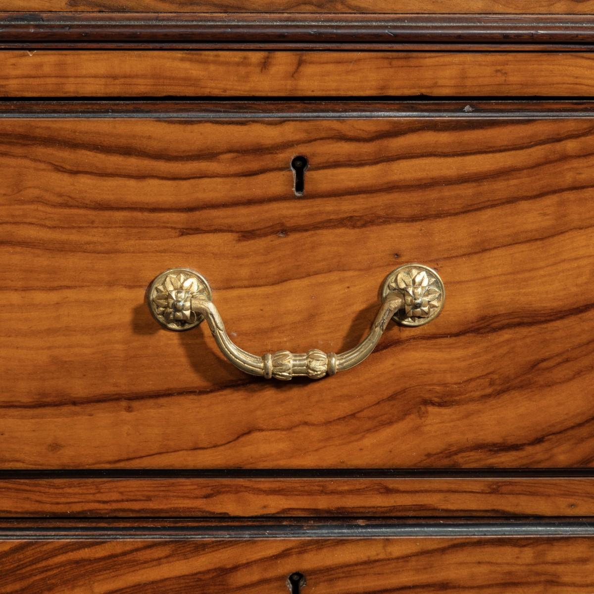 This pedestal desk has a rectangular leather inset top and supports a small shelf with an openwork ormolu grille and small columns. The kneehole is flanked by three drawers on either side and has a writing slide disguised in the central frieze
