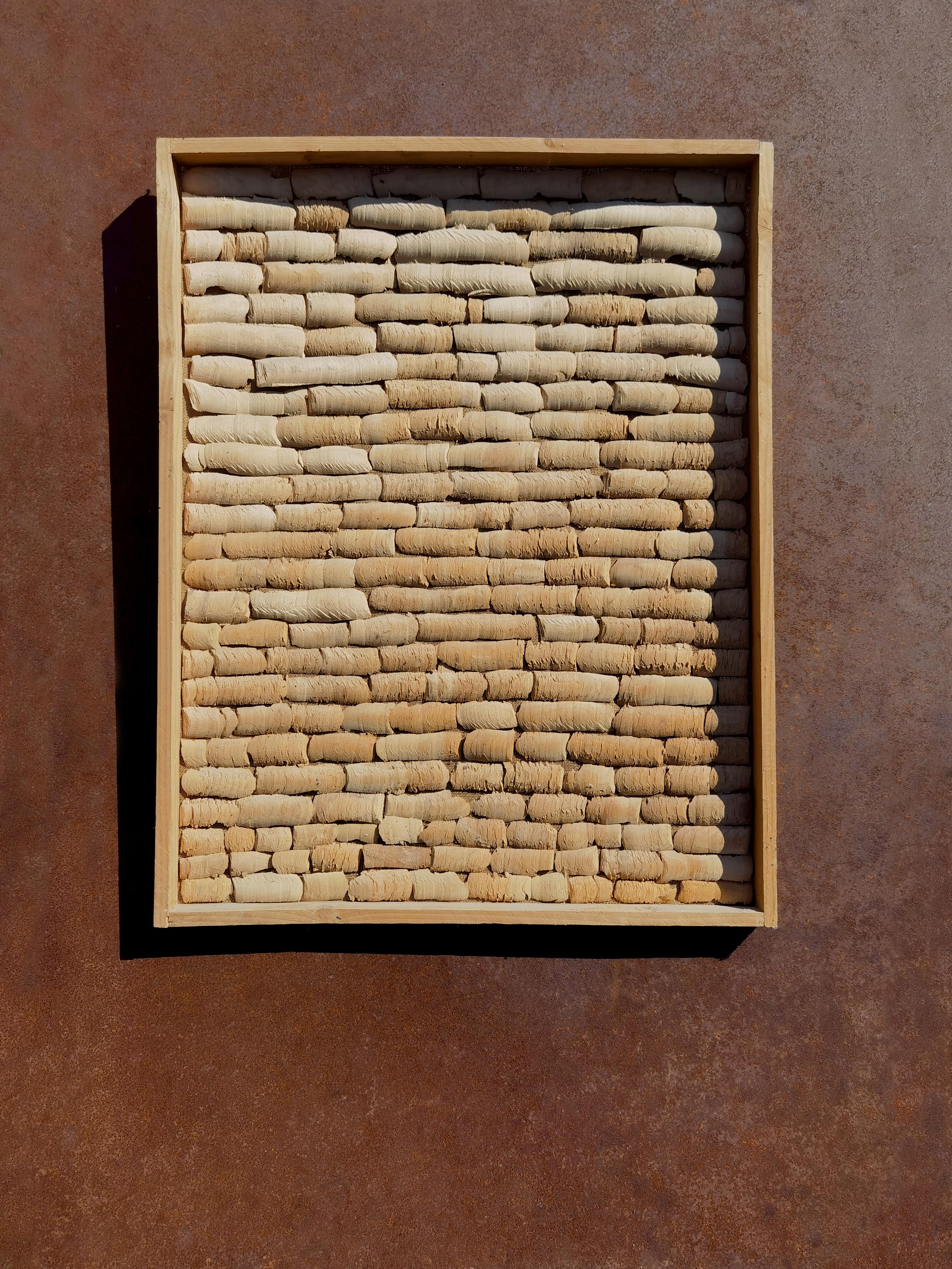 A rectangular relief work, wall sculpture , Abstraction, Brutalist, Primitivist, Tribal, Systematic composition of mounted wood bark, forming a very graphic, even kinetic, rhythmic movement, on a raw canvas stretched in a raw wood frame. by Benoit