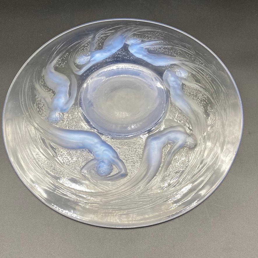 The Ondines plate is one of R.lalique 's iconic pieces .

The famous design of the mermaids swimming around the dish is one of R.Lalique favorites illustrations of the grecian mythologie and often bounces back in his classical inspiration.

While