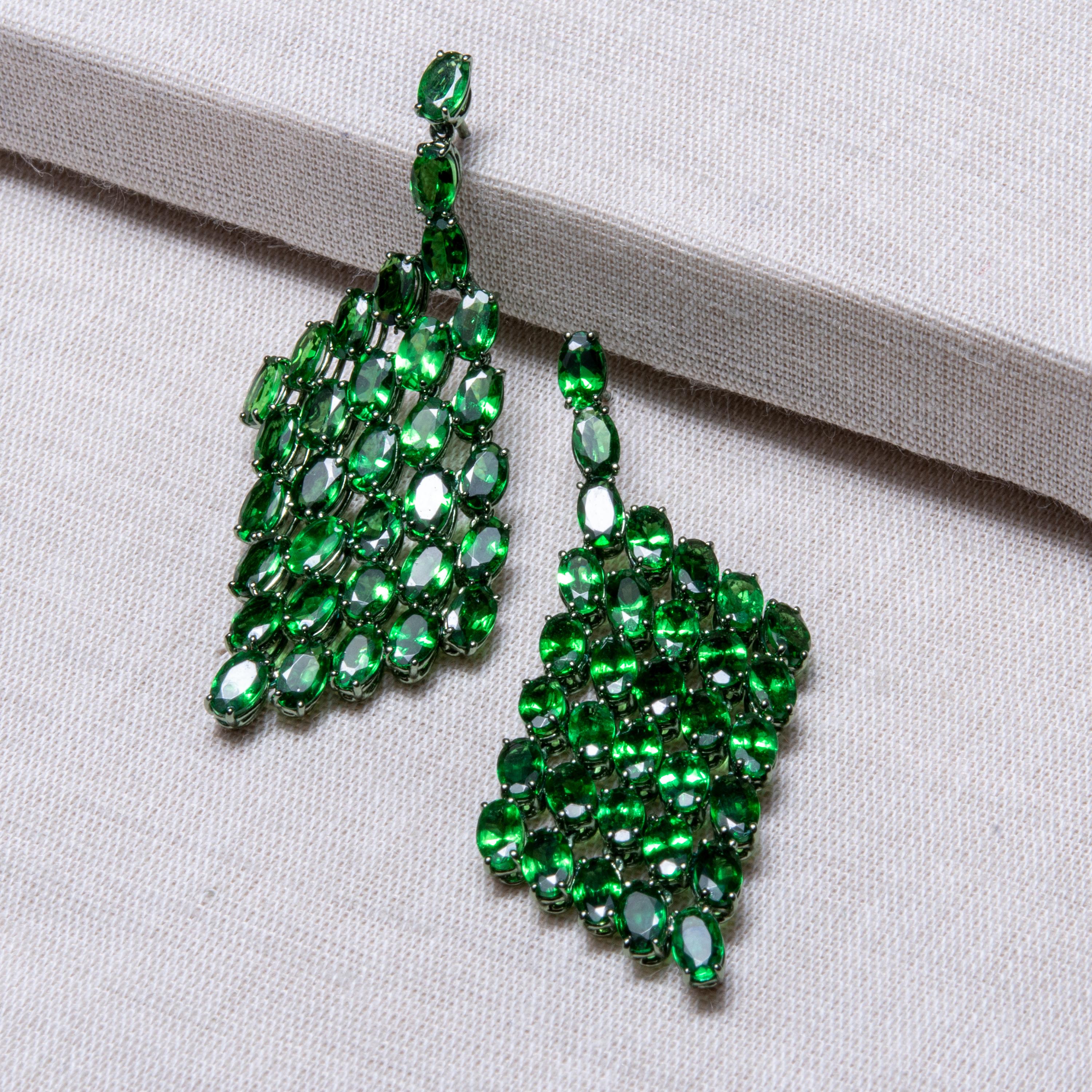 Collection: The Gem Made Me Do It

Title: “The Tsavorite Dream” Earrings

These 64 tsavorites wanted to stay together holding hands and hanging loose so we weaved them together to make a Tsavorite cloth dangle earrings. When you hold this pair of