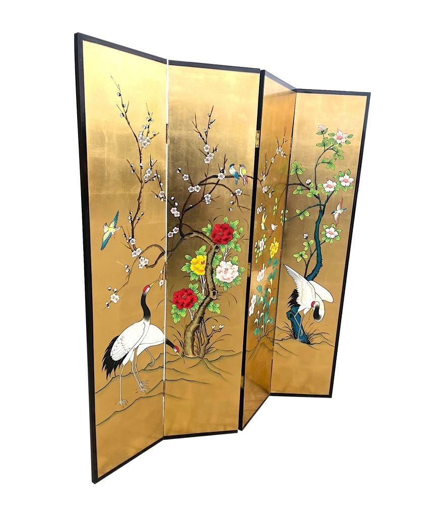 A 1970s oriental gold leaf and hand painted four panel, brass hinged screen beautifully hand painted and decorated on the front with cranes, flowers, blossom and birds. The back is decorated with black lacquer with gold bamboo trees.