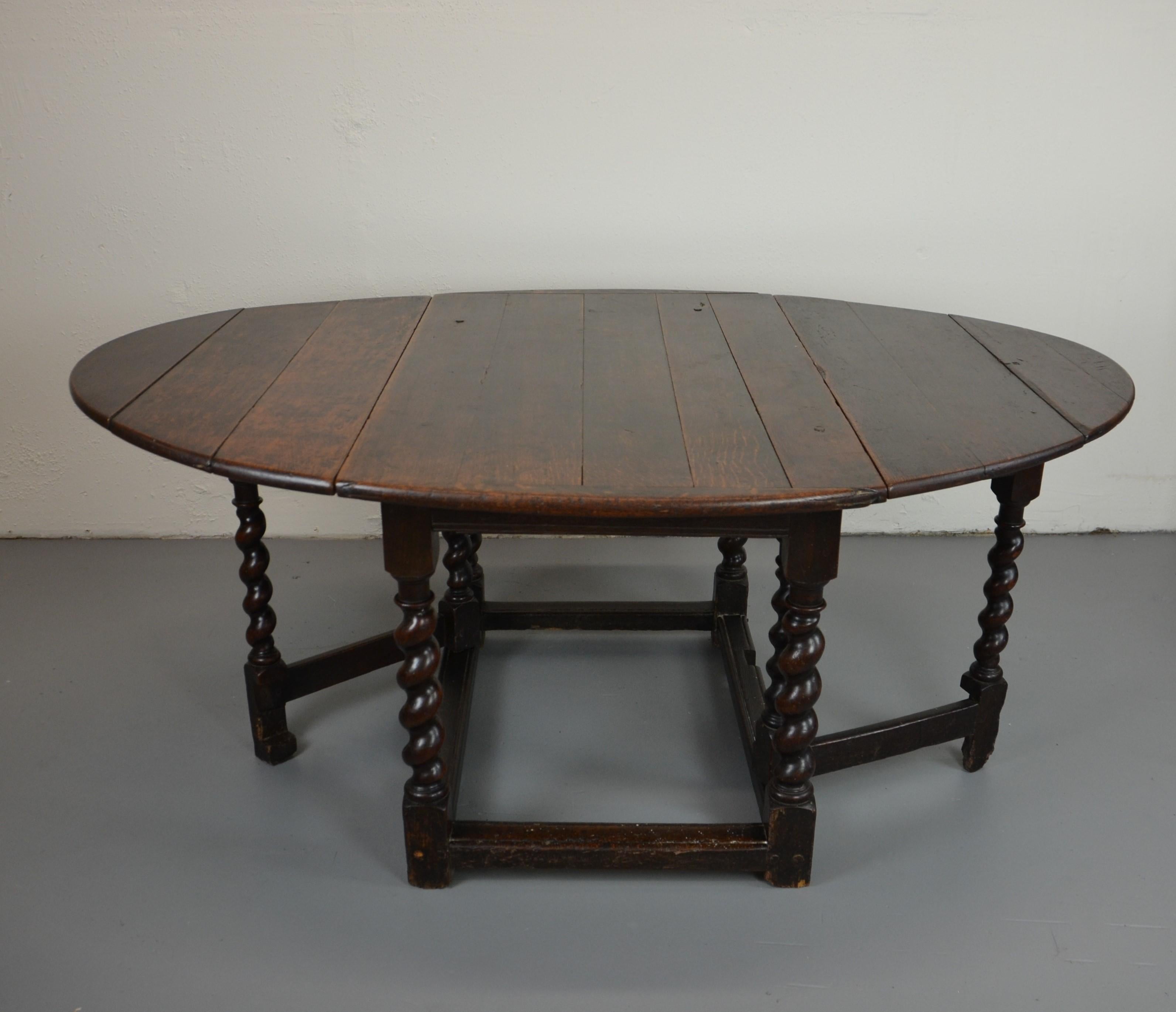 This is an original English solid oak gate-leg table from the late 17th century. Solid planks, early handmade ironwork hinges. Open 65