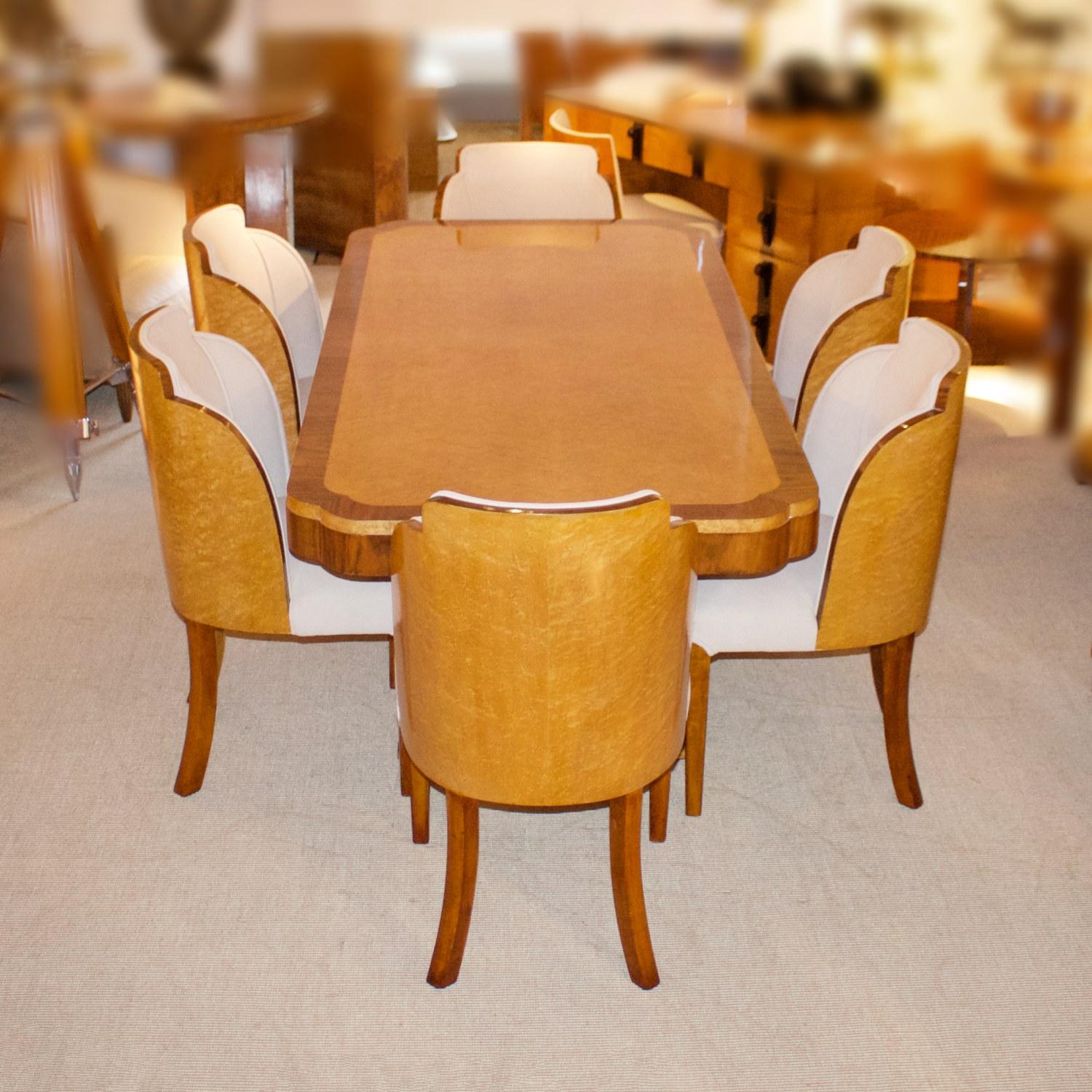 An Art Deco 6-seat cloud form dining suite by Harry & Lou Epstein bird's-eye maple and burr walnut Veneered tabletop over a bird's-eye maple and walnut U-shaped base. Six cloud backed dining chairs with bird's-eye maple veneers and solid walnut