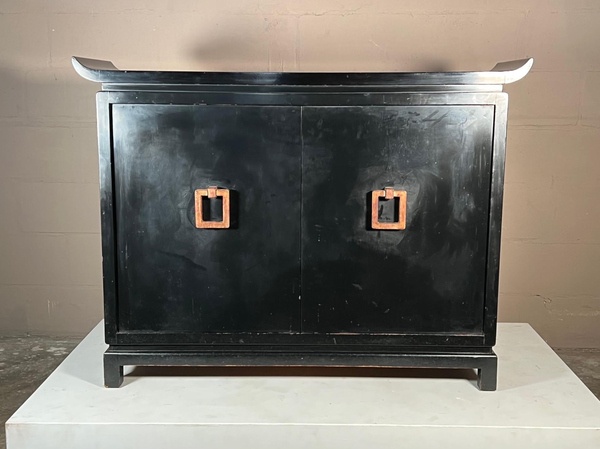 Rare meuble de rangement de James Mont de style chinoiserie. Laque noire d'origine et intérieur peint en rouge. Poignées en bois doré d'origine.