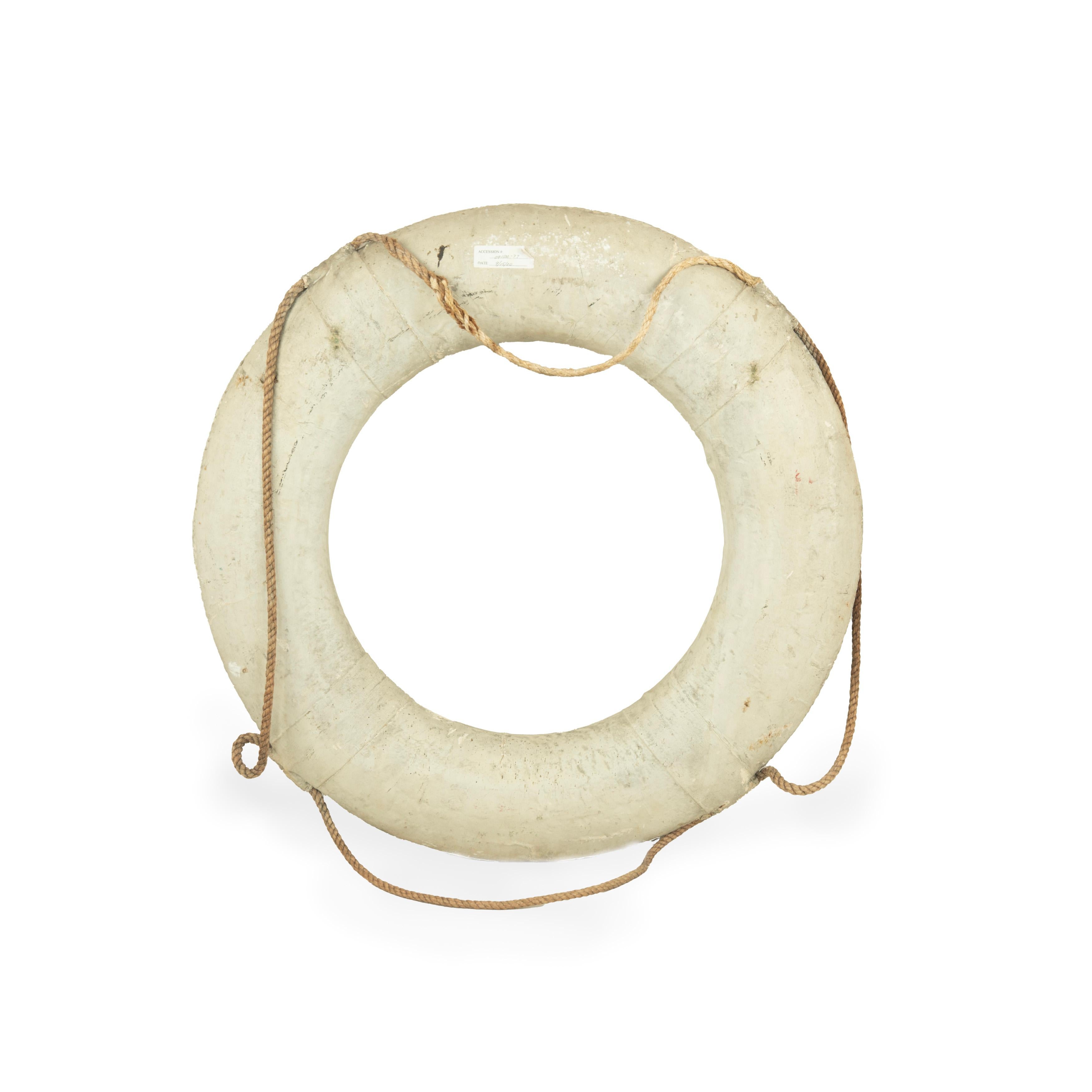 An original life ring from the America’s Cup yacht ‘Shamrock’, Royal Ulster Yacht Club, the circular ring painted in gilt outlined in green ‘Shamrock V, R.U.Y.C.’, on a white ground, with the original rope handles threaded though canvas straps. 