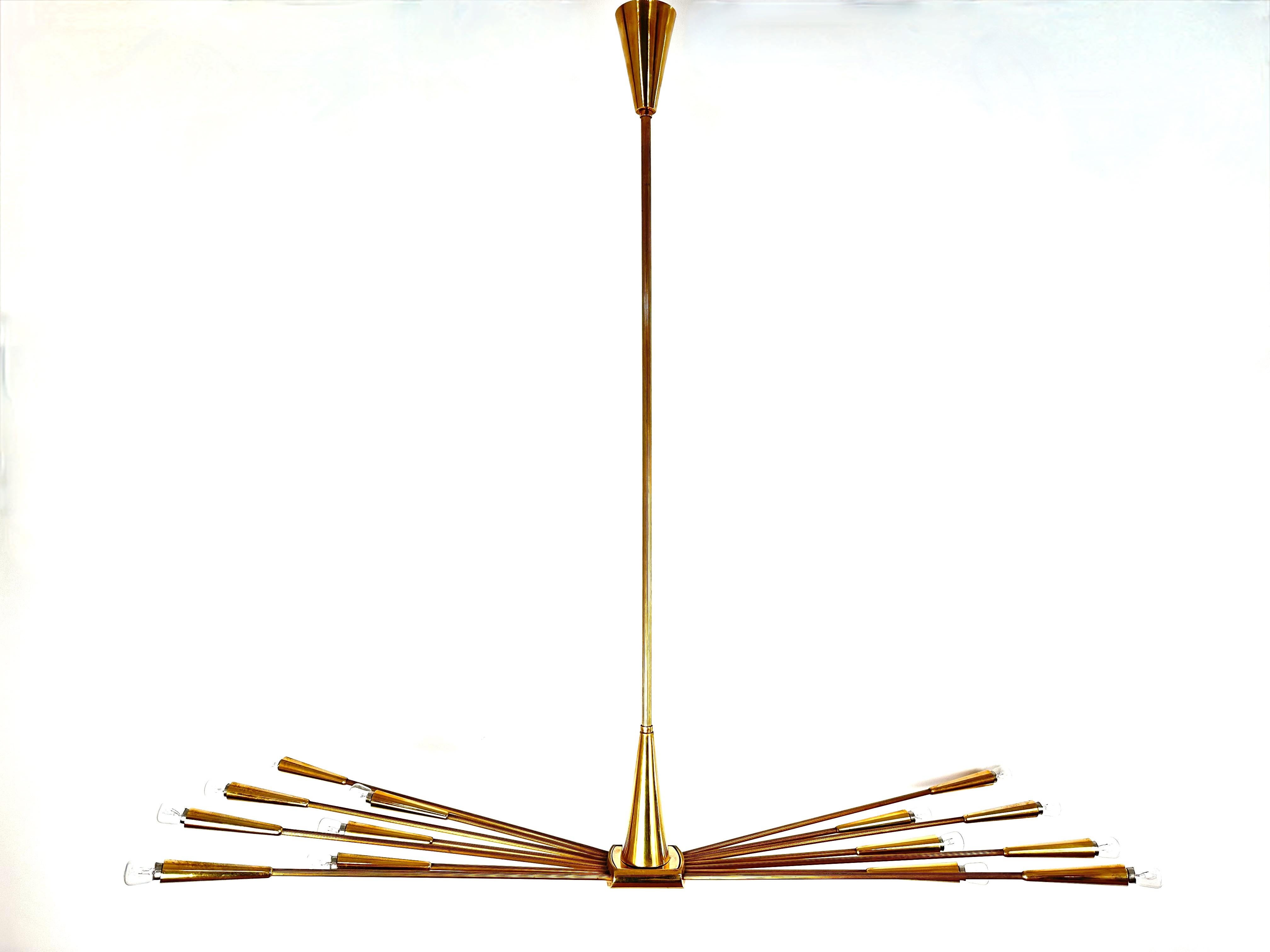 An original vintage Oscar Torlasco Sputnik Chandelier edited by Lumi in the 50s.Framed in  Mirror-polished brass.Fourteen  arms, long and short and a striated shaft adjustable in height.Excellent condition.A collection piece.
