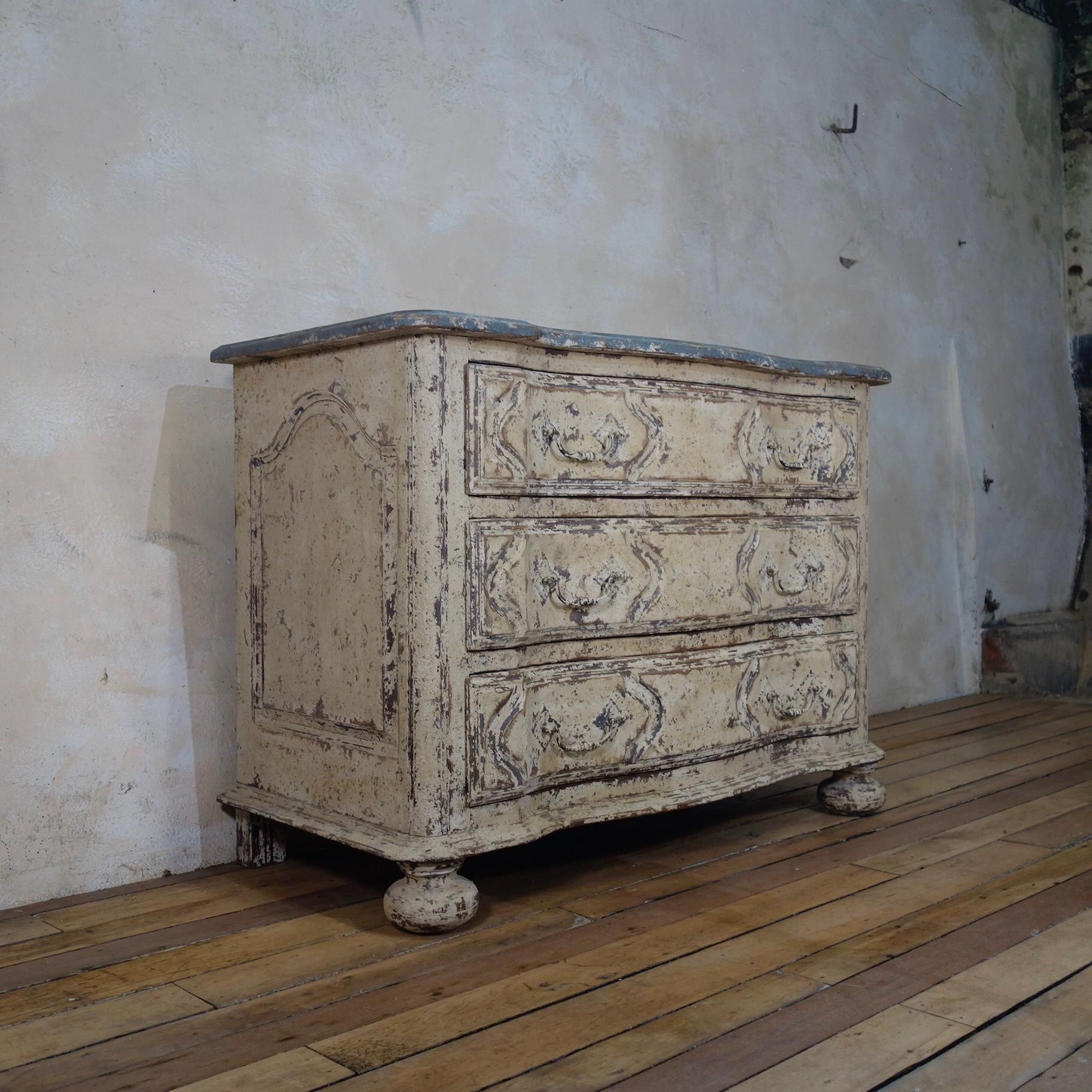 Striking early 20th century French oak serpentine commode, of great proportions displaying original paint. Demonstrating elegantly carved paneled sides and a graceful serpentine shaped front, raised on charming bun feet retaining its original